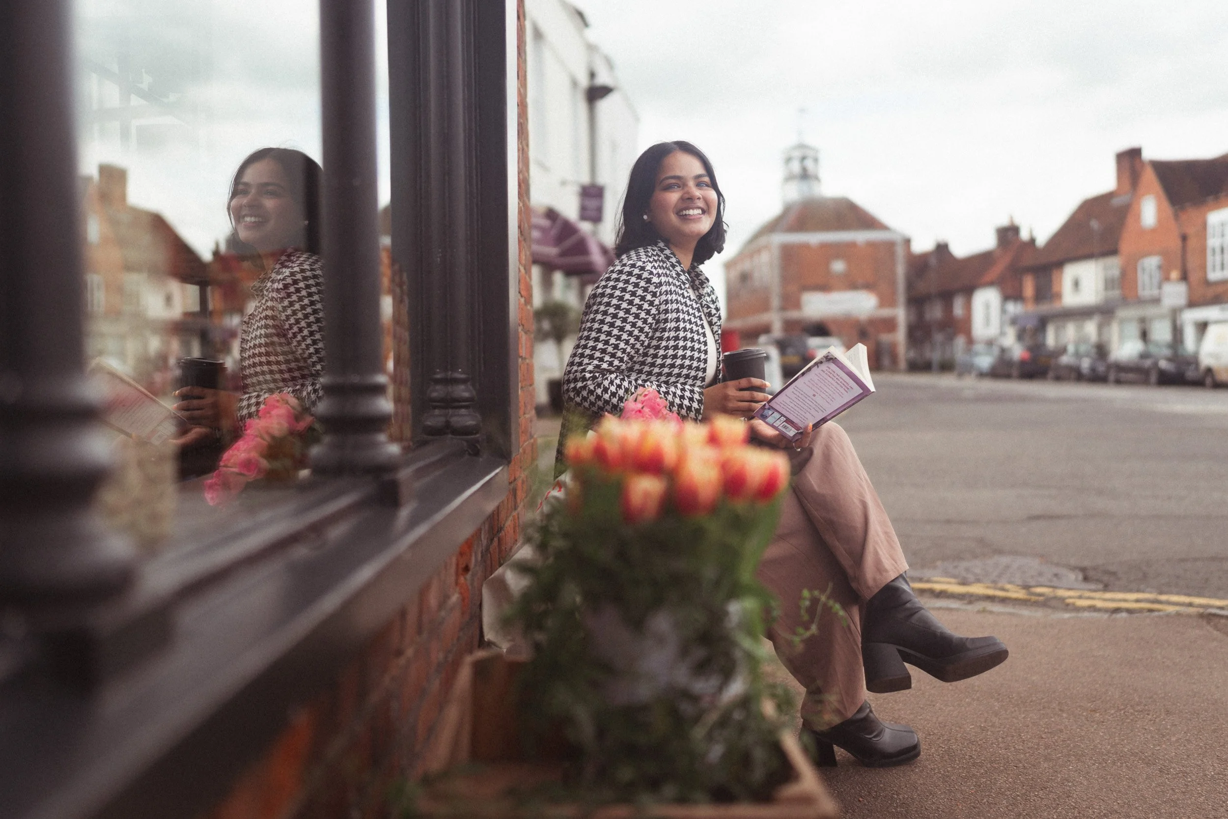 Social media influencer sitting outside The Grocer with a coffee and book in Old Amersham, Buckinghamshire during a branding shoot