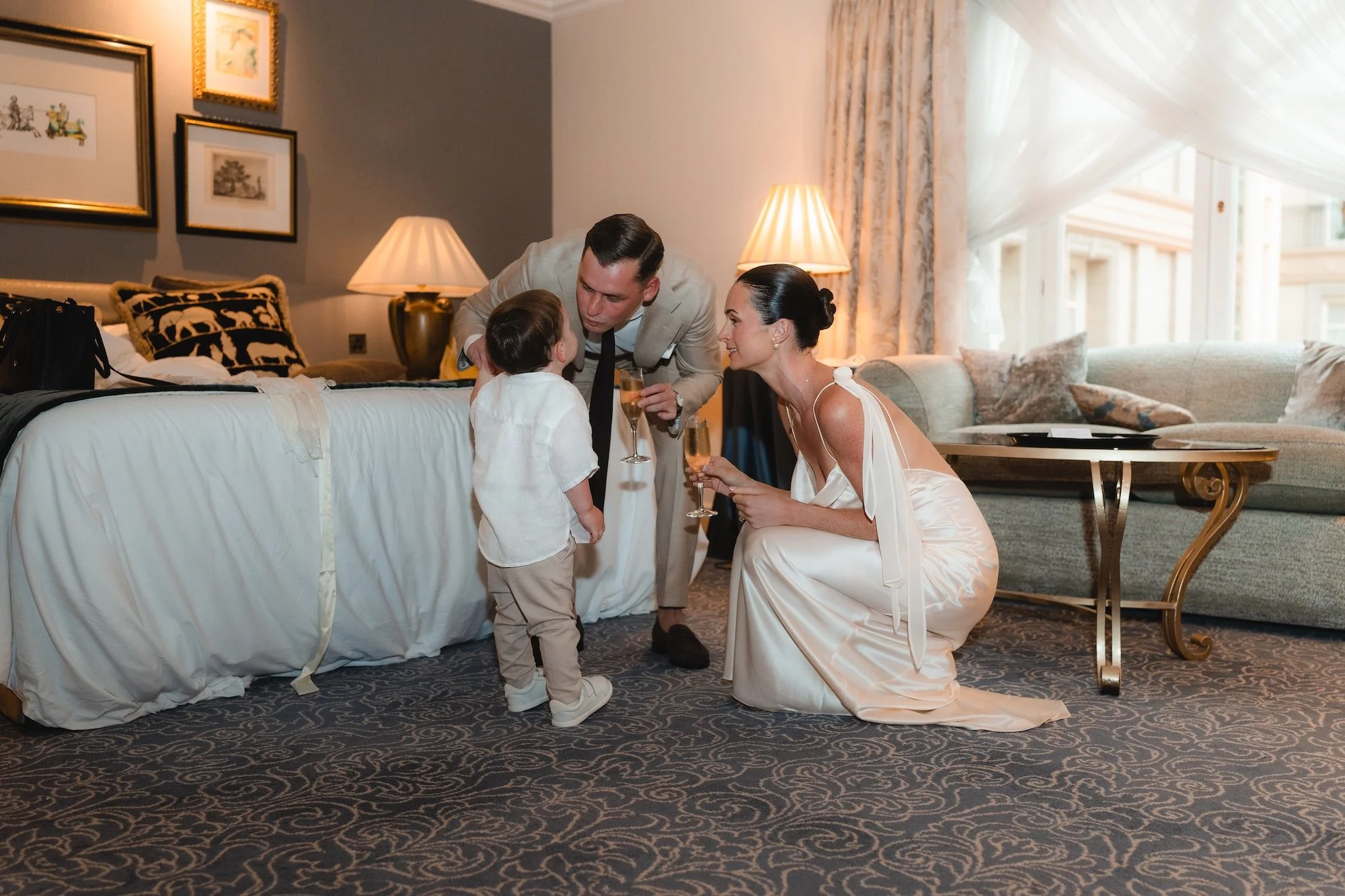 Bride and groom sharing a quiet moment with their little boy in their suit at The Landmark London before their Old Marylebone Town Hall London Micro Wedding