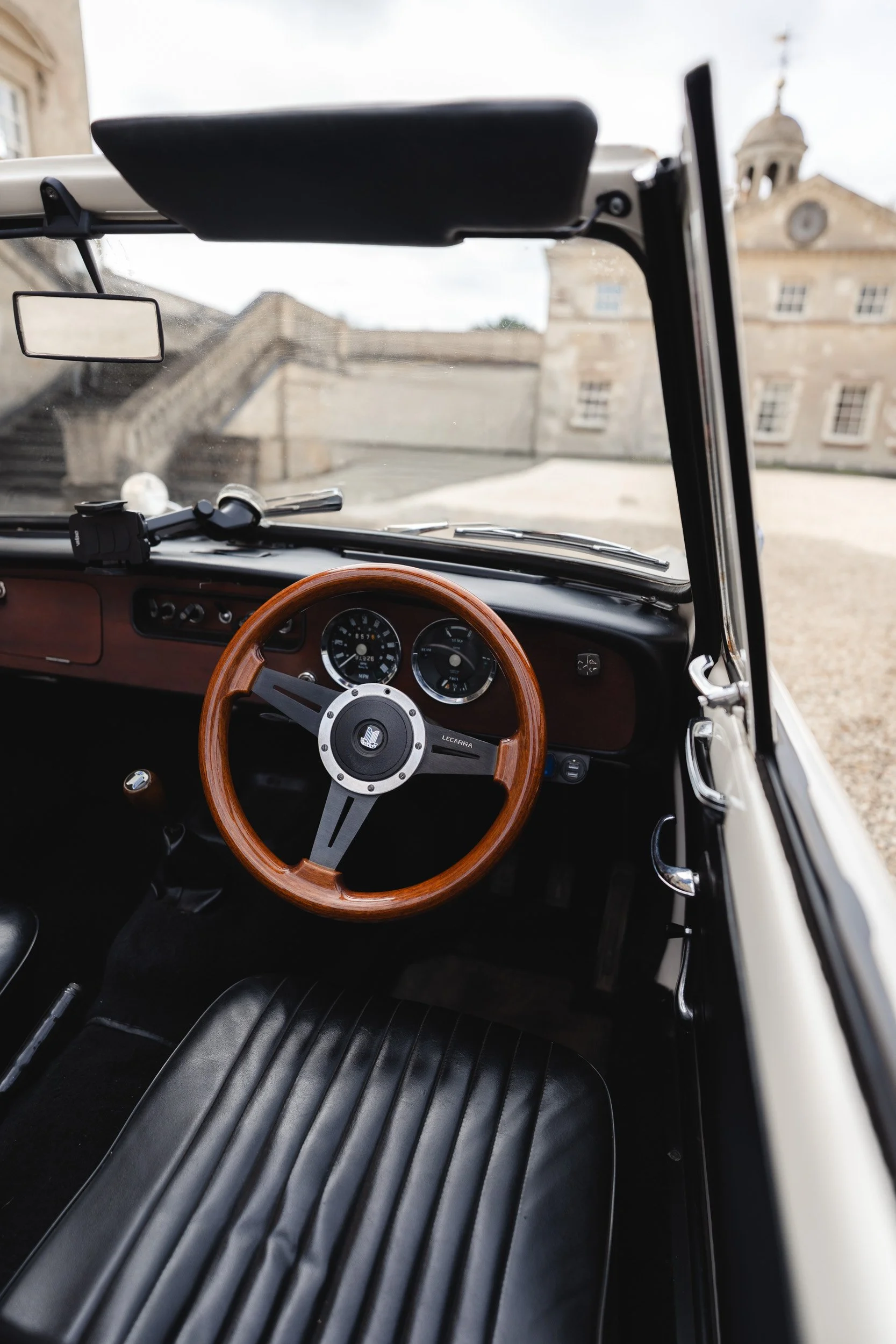 Steering wheel of a Vintage Wedding car outside Kirtlington Park in Oxfordshire