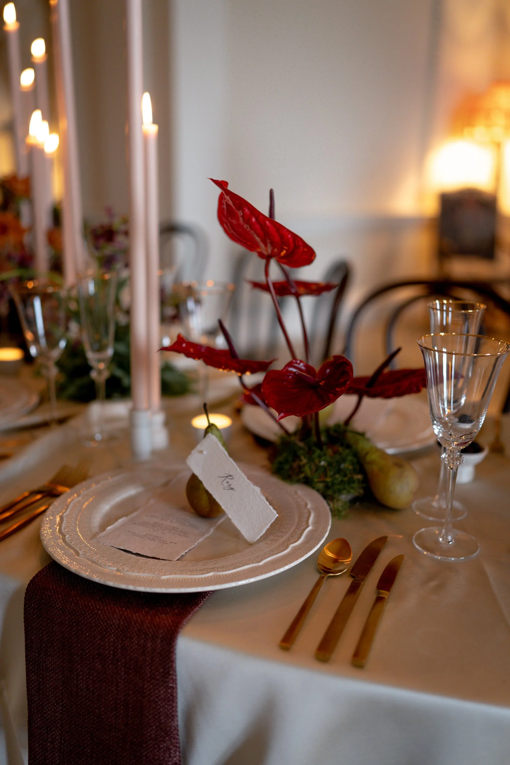 Floral and candle lit table setting at a wedding reception at Kirtlington Park in Oxfordshire featuring soft pink florals and candles