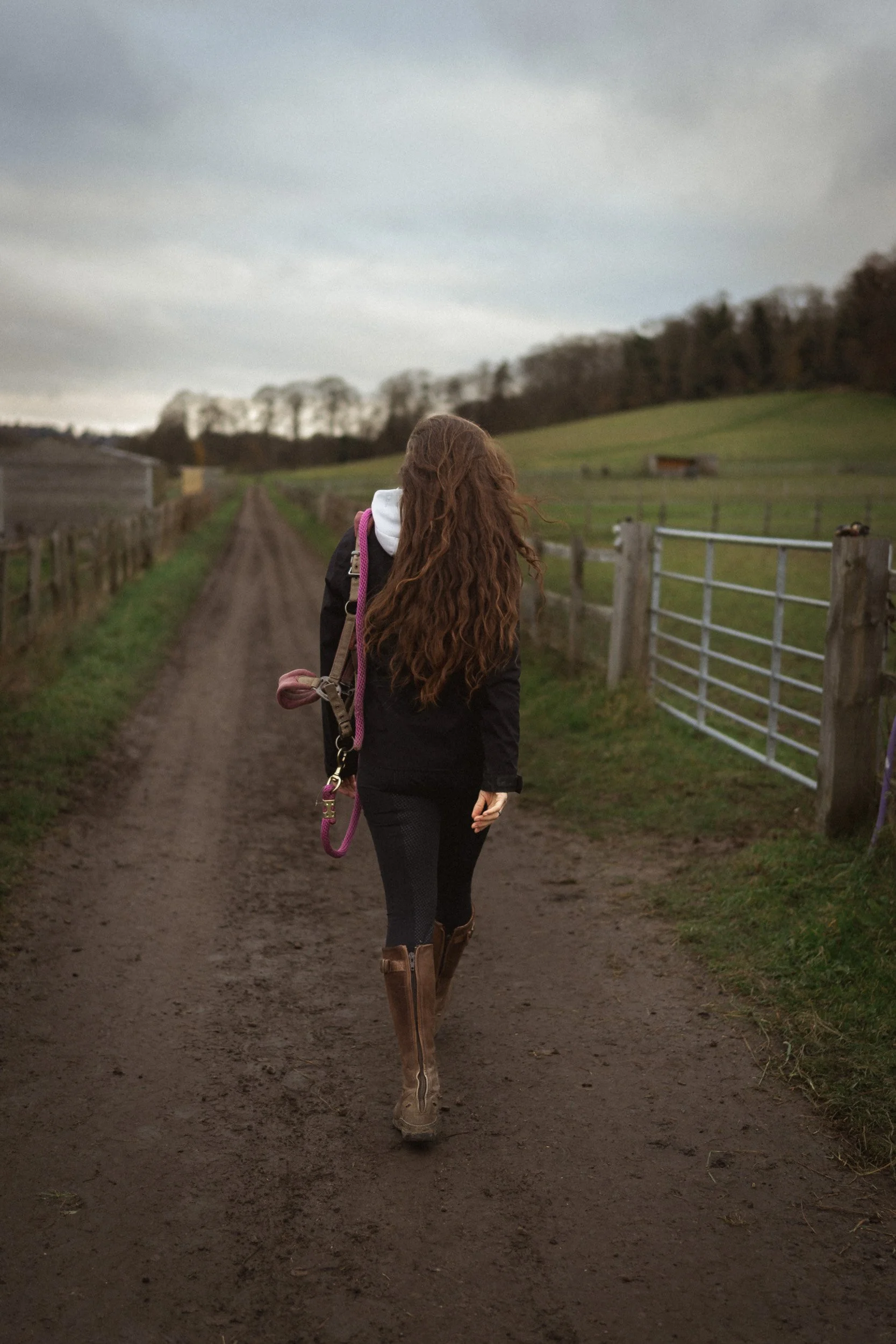 Equestrian fitness coach walking along a country track at Sean Hardy Horse Training in Great Missenden Buckinghamshire during a branding session
