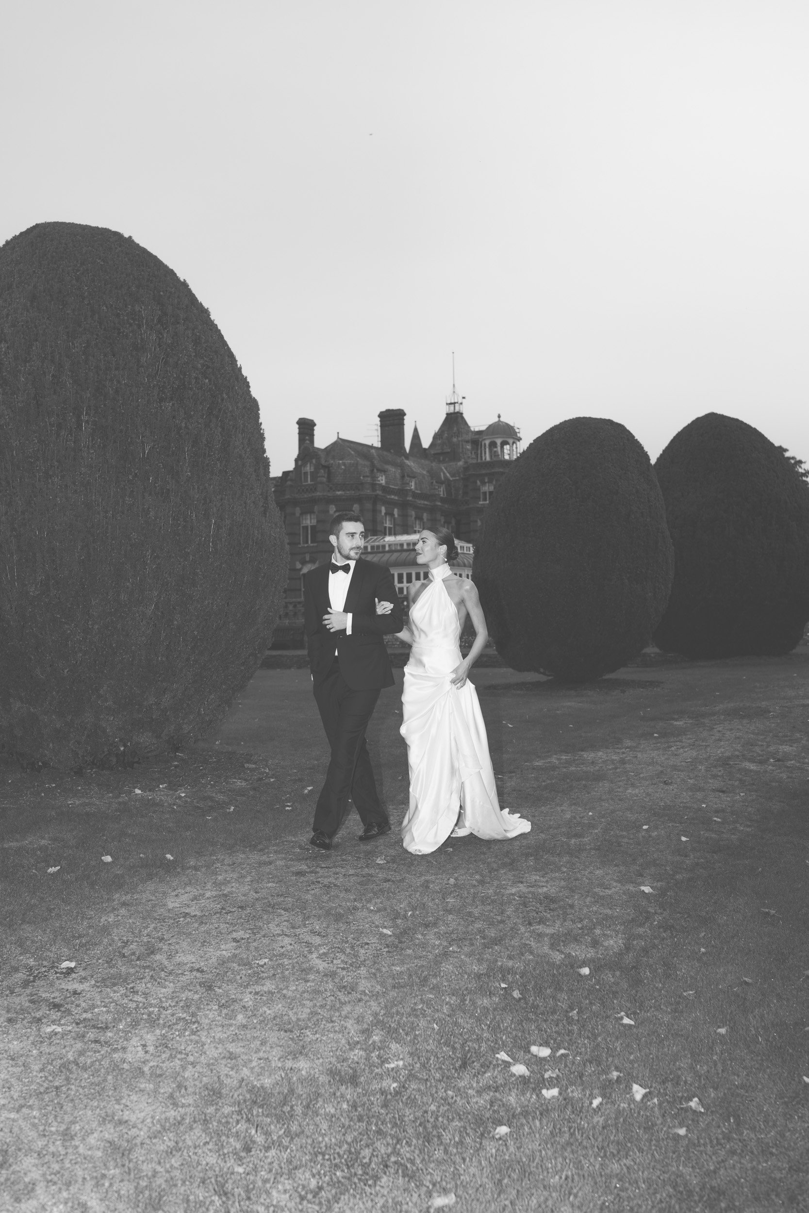 Bride and groom having an evening stroll  in the gardens of The Elvetham Hotel in Hampshire during their wedding reception