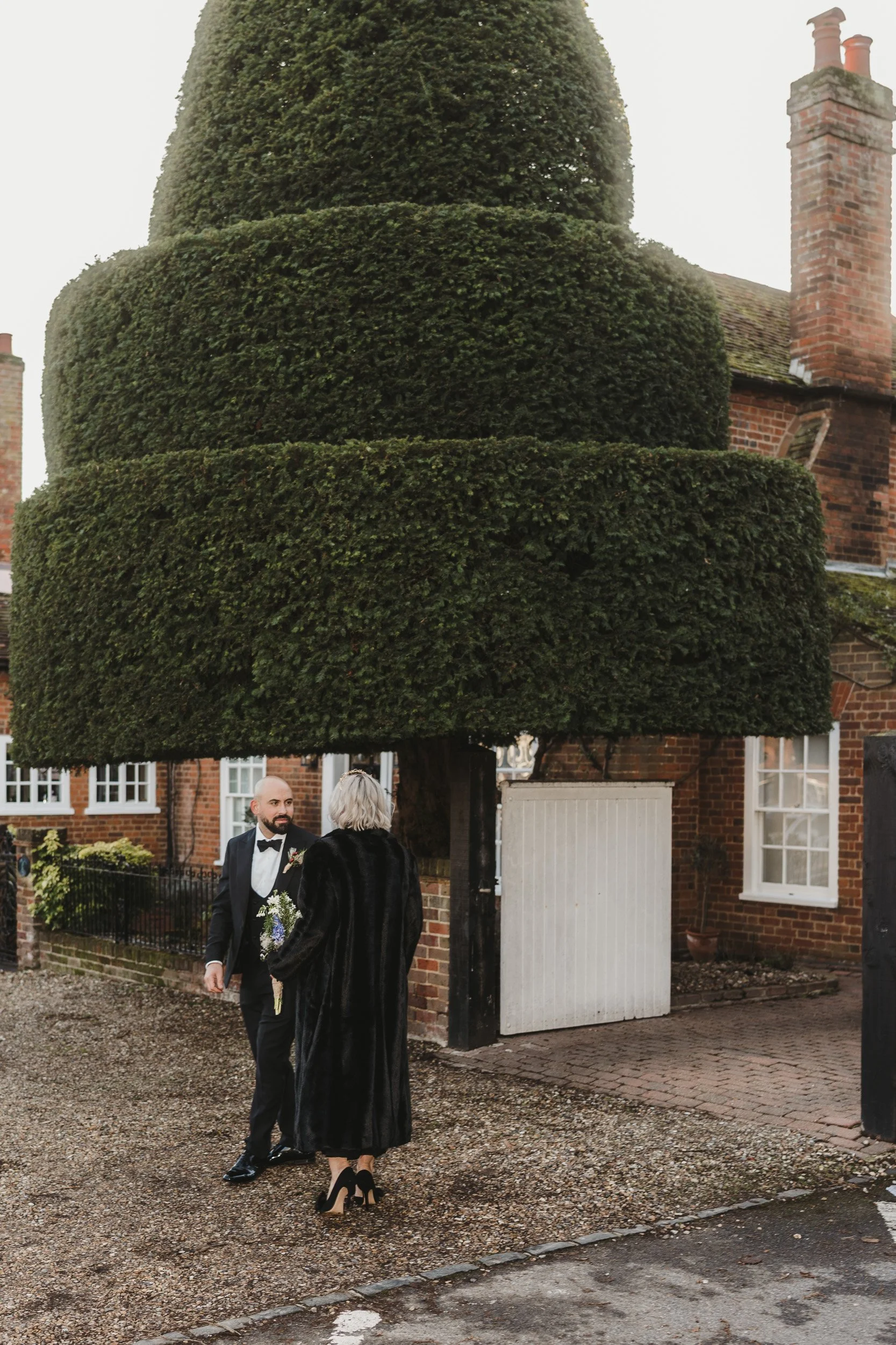 Bride and groom waiting near the church in Old Beaconsfield Buckinghamshire before their wedding ceremony