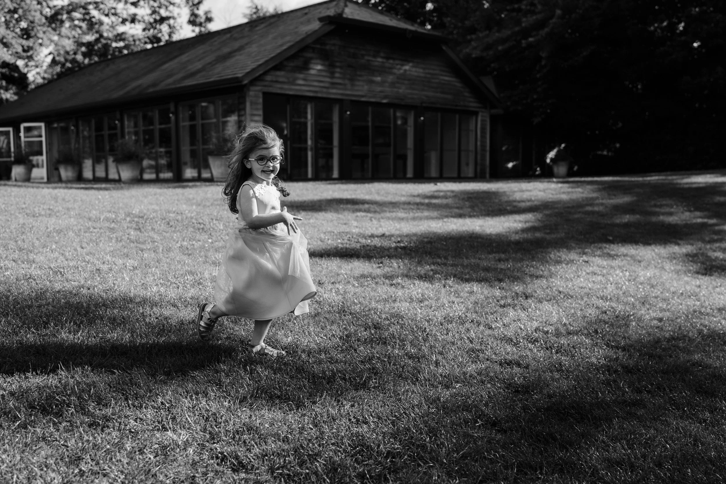 Flower girl running over the lawns of Wasing Park in Berkshire 