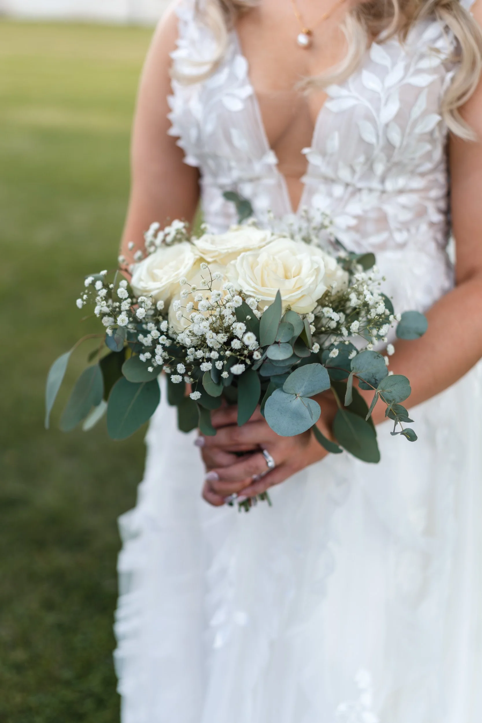 Close up of the bride's hands holding her bouquet on the lawns of Wasing Park in Berkshire 
