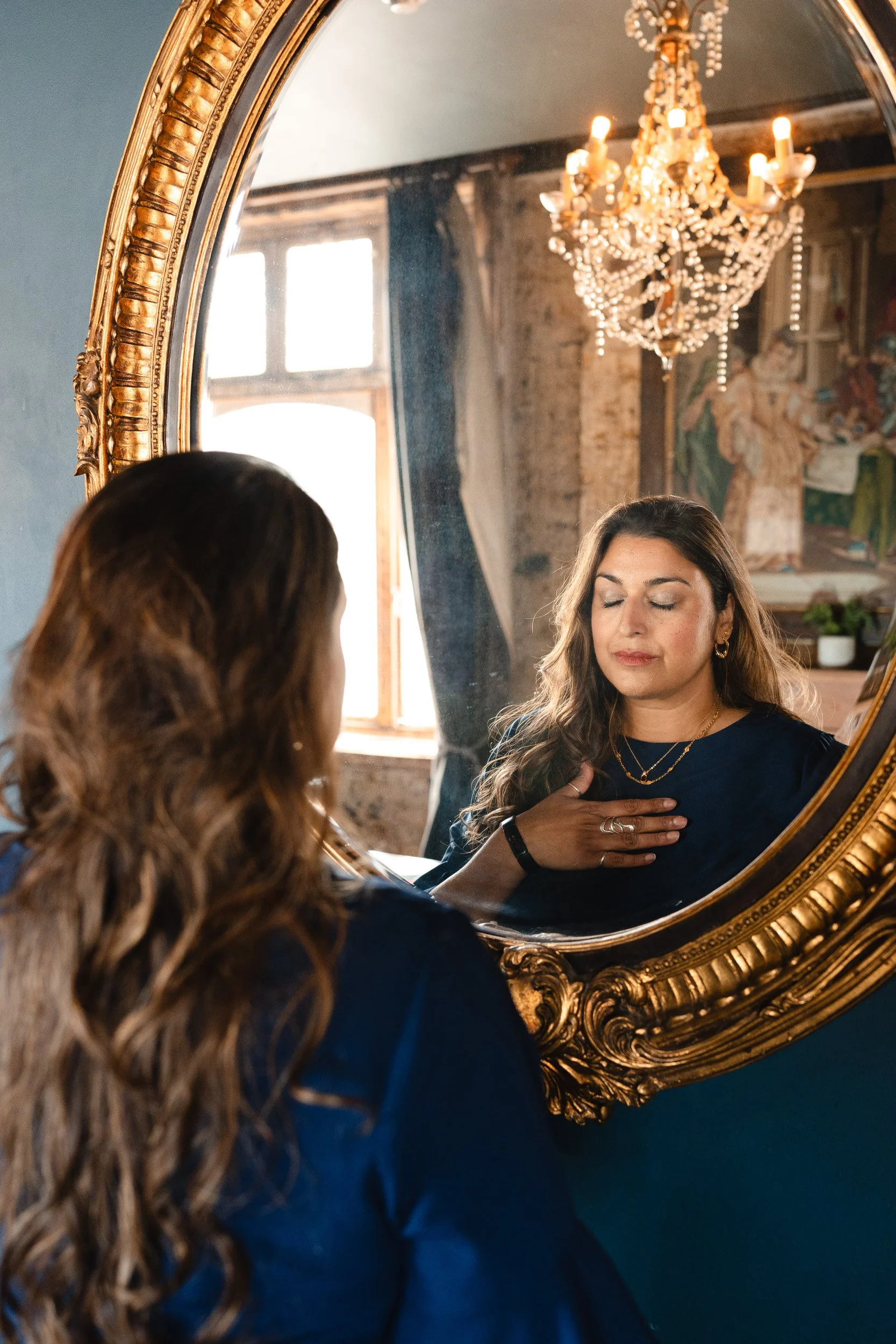 Breathwork coach practicing mindful breathing in a mirror during a personal branding photoshoot in Hackney London