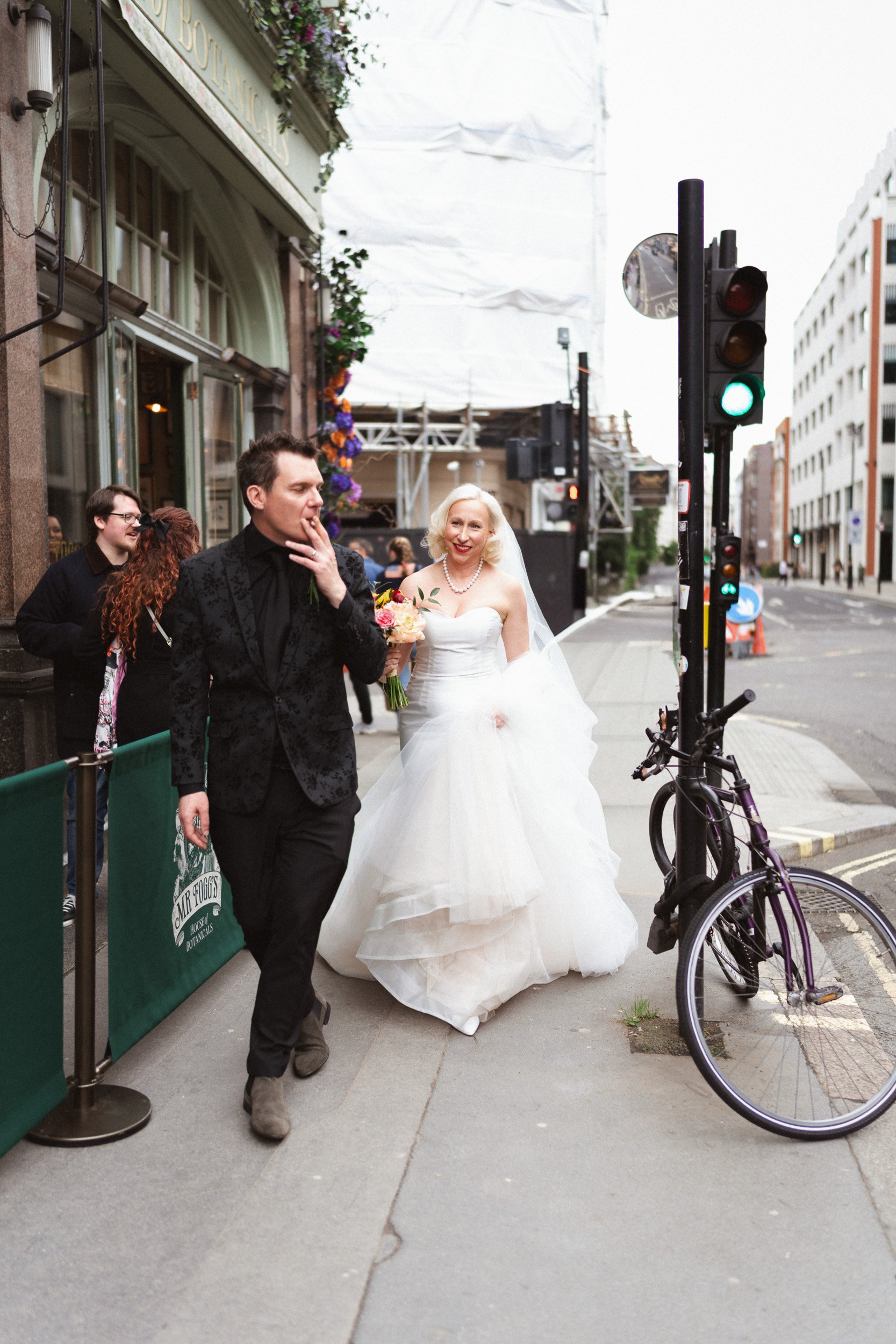 Bride and groom hurry through Soho Streets after their wedding ceremony at Fitzrovia Chapel 