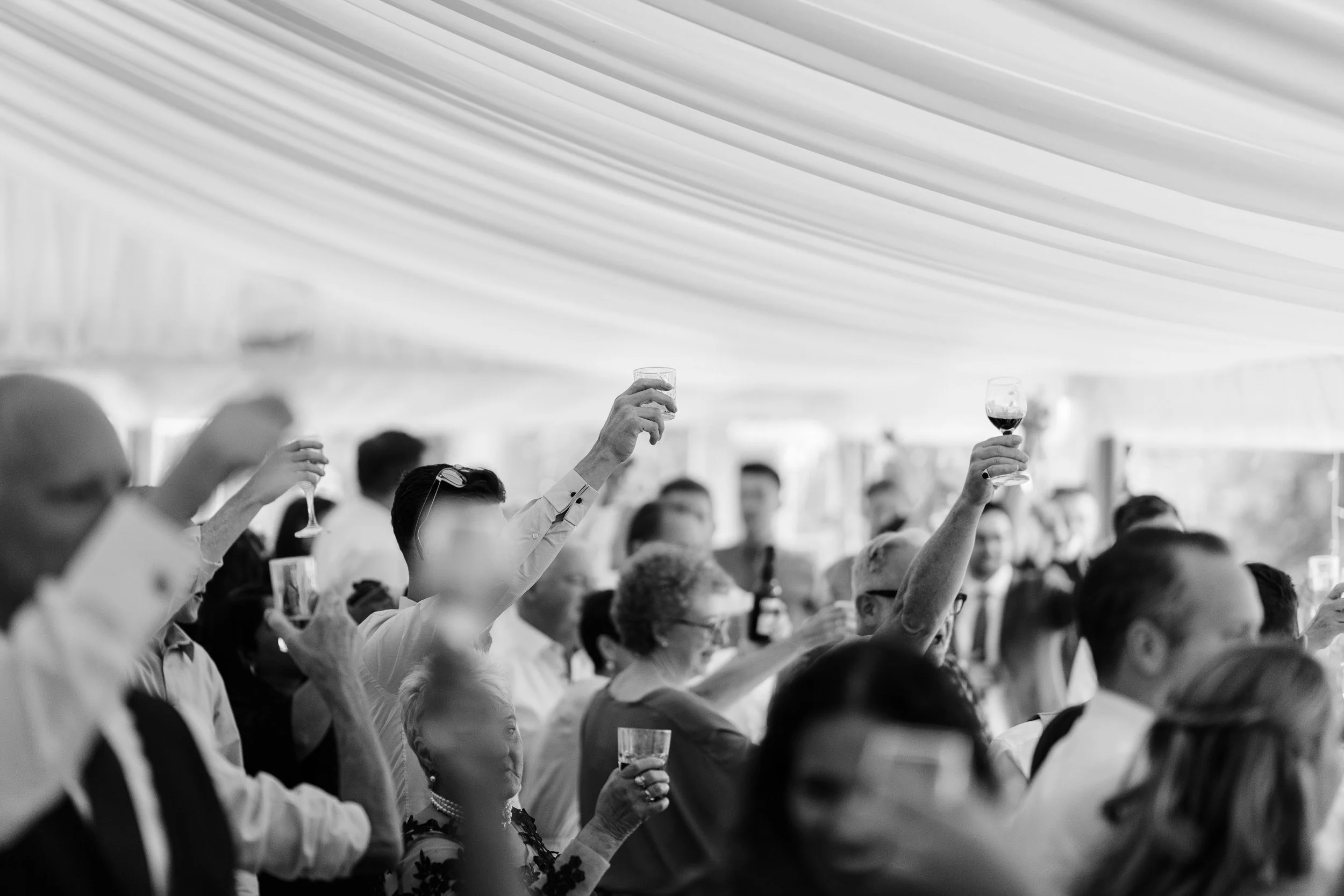 Wedding guests cheering during speeches at Cherwell Boathouse in Oxfordshire