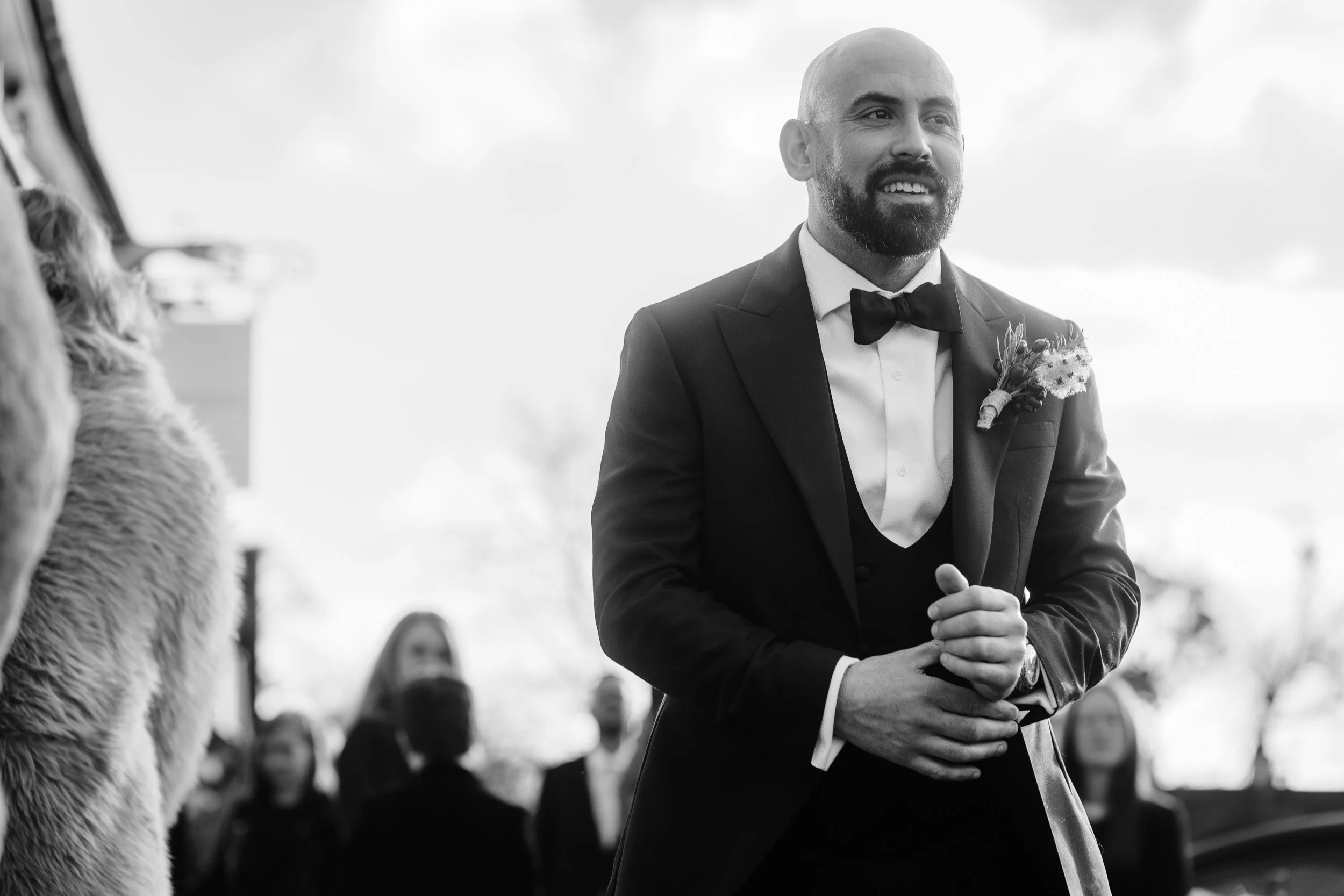 Groom adjusting his cufflinks and walking towards the Registry office in Old Beaconsfield Buckinghamshire 