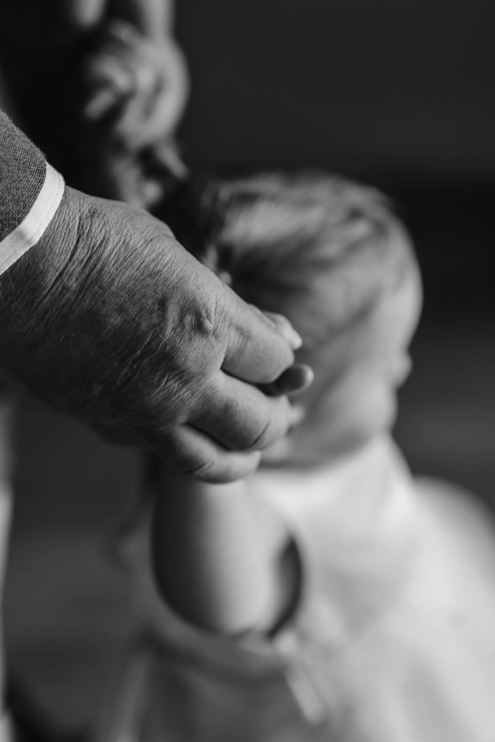 Close up of the father of the bride walking with his granddaughter  during the wedding reception at Rivervale Barn in Hampshire