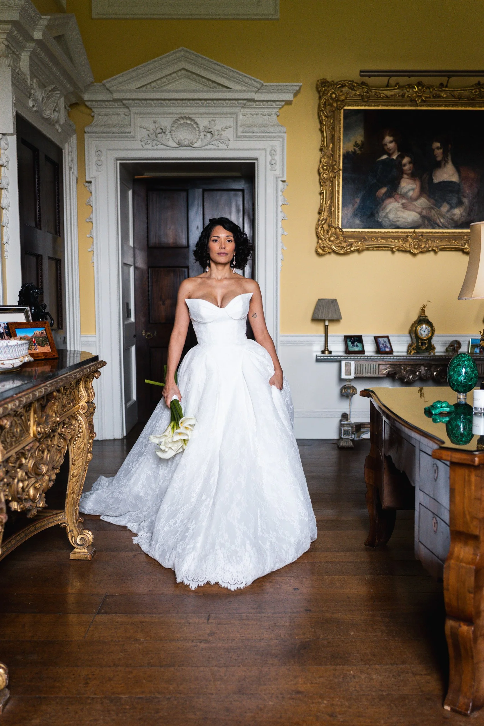Bride walking through an elegant room in her wedding dress at Kirtlington Park in Oxfordshire