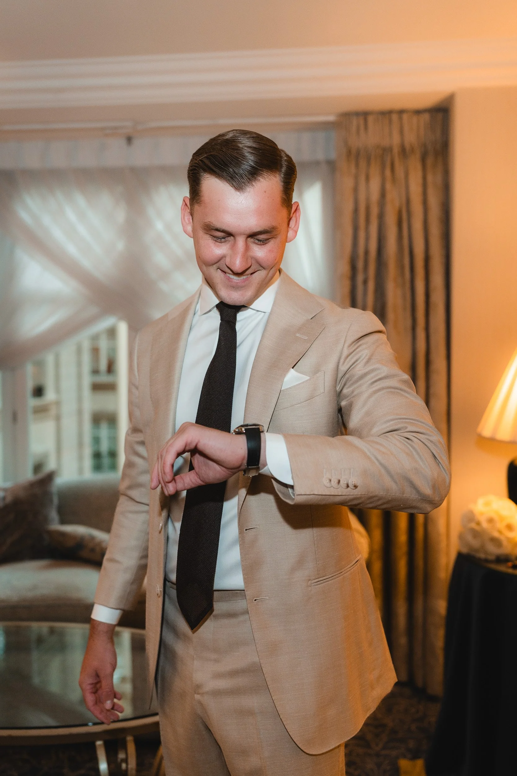 Grooms checks his watch in an elegant suite at The Landmark Hotel in London Marylebone 