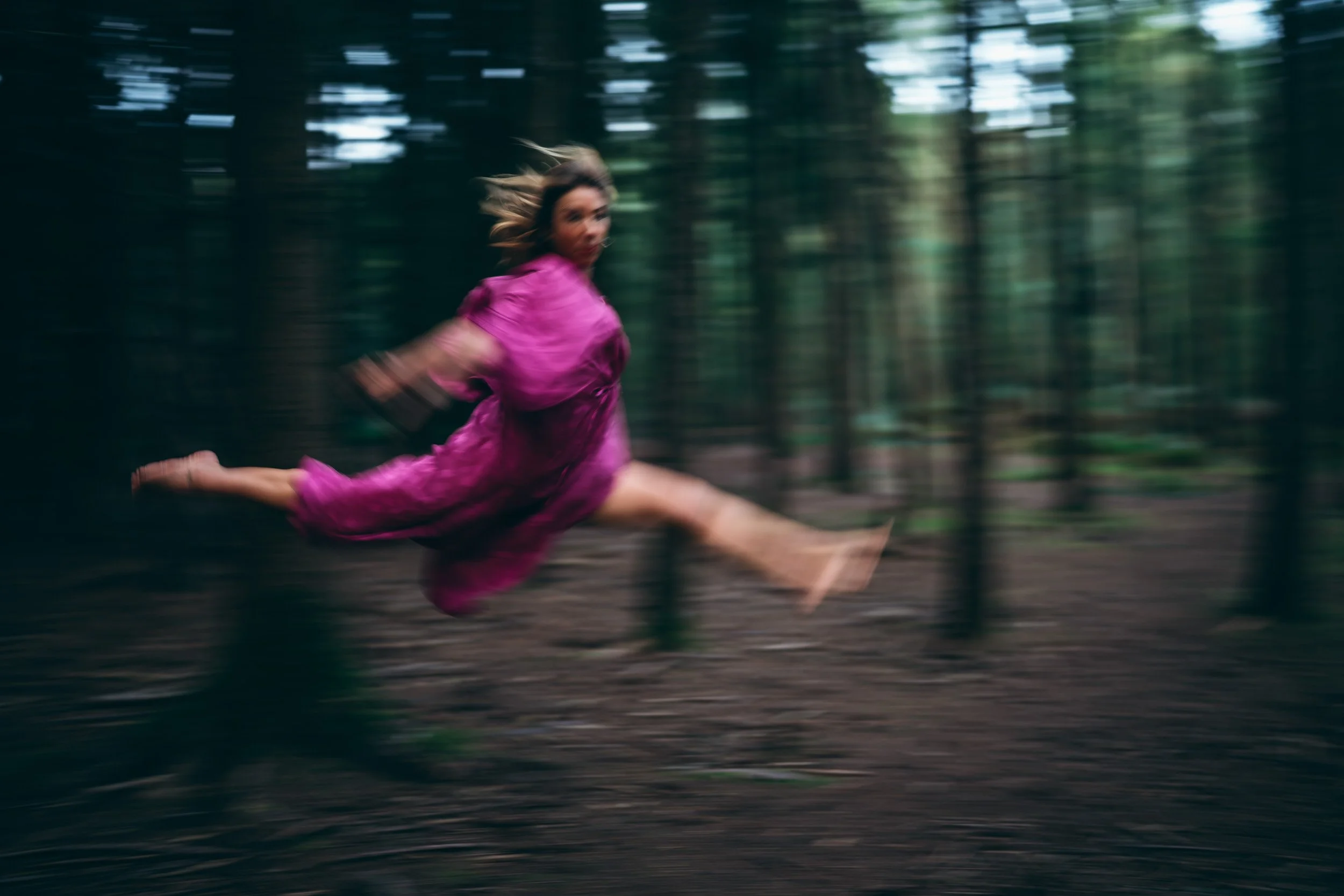 Yoga trainer jumping in the woods during a personal branding photoshoot in Black Park Buckinghamshire