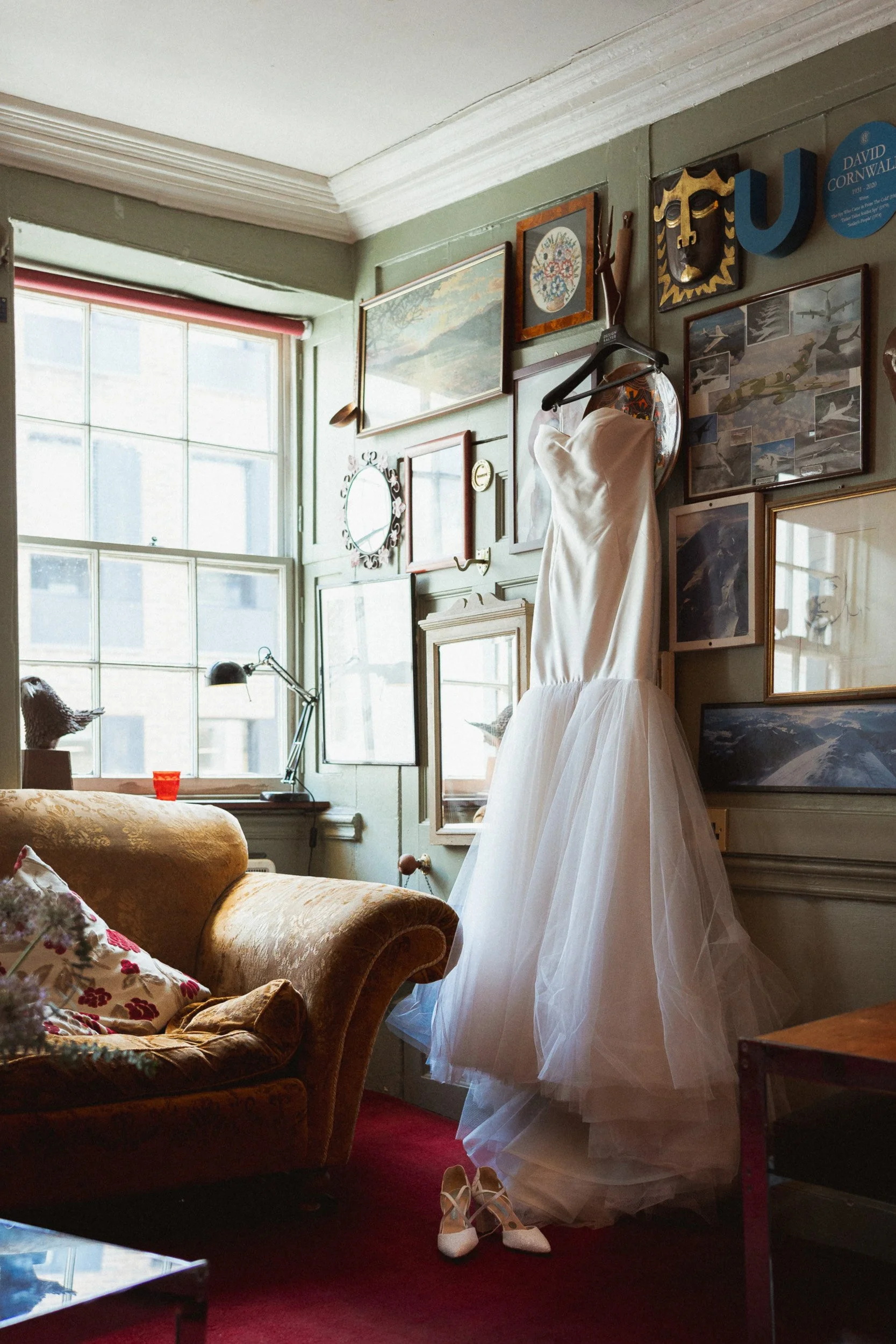 Wedding dress hanging on a gallery wall in a private room  at The Union Club in Soho, London