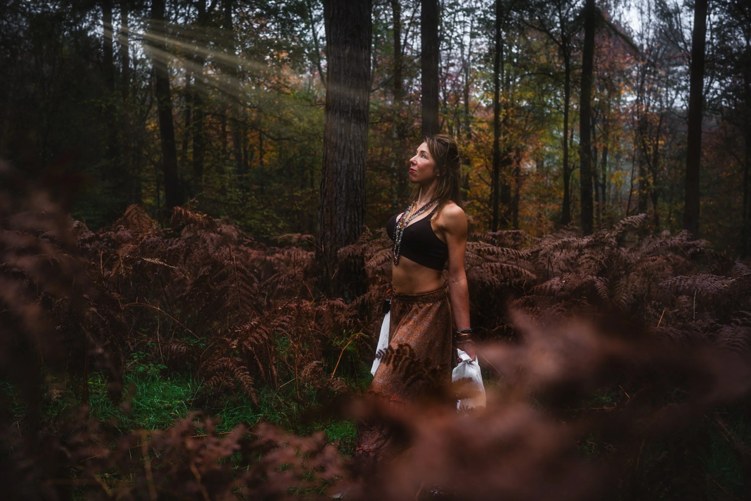 Sound healer walking through the woodland during a personal branding photoshoot near Amersham Buckinghamshire