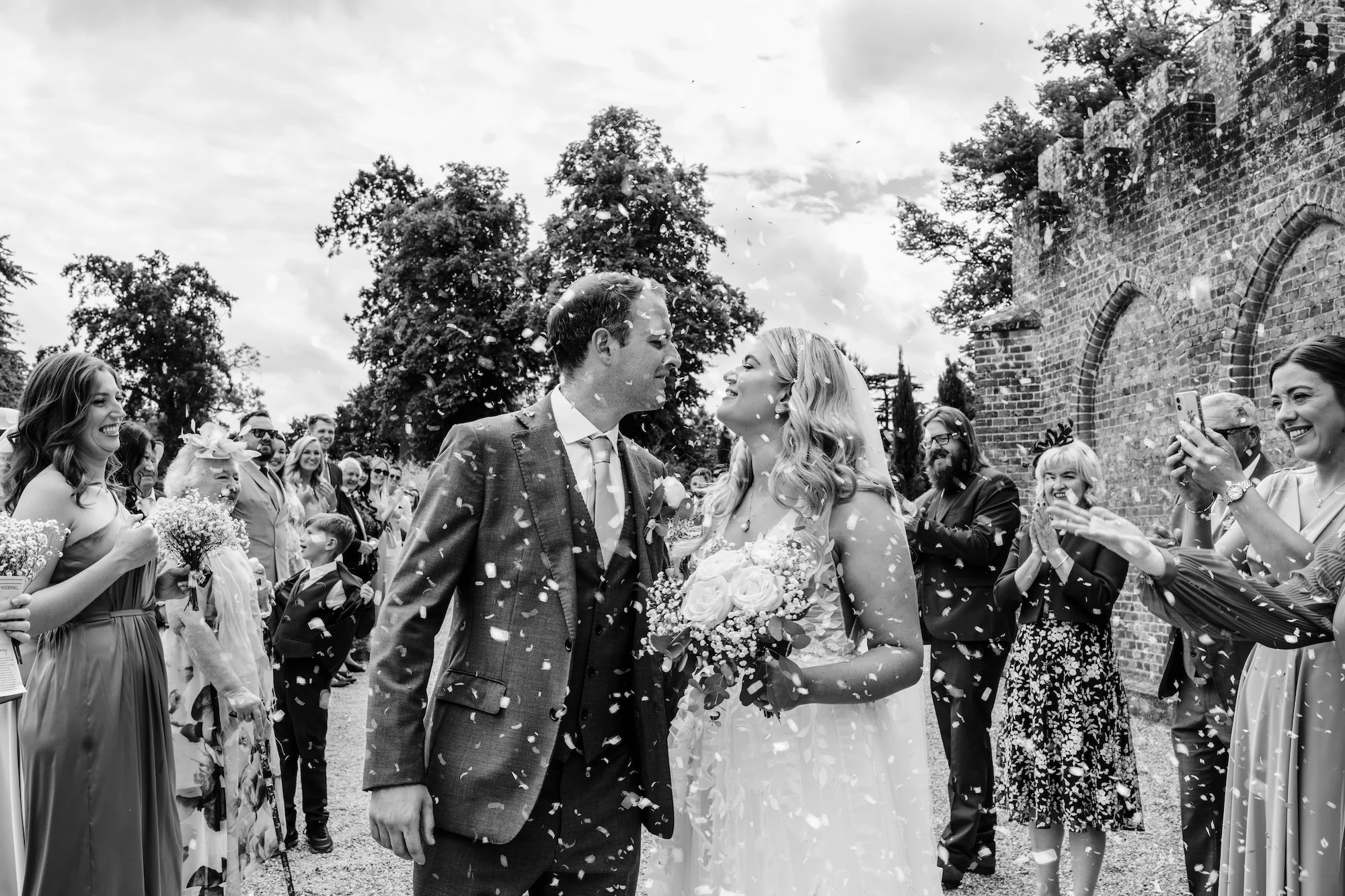 Newlyweds walking through a confetti throw with their guests at Wasing Park a Wedding Venue in Berkshire