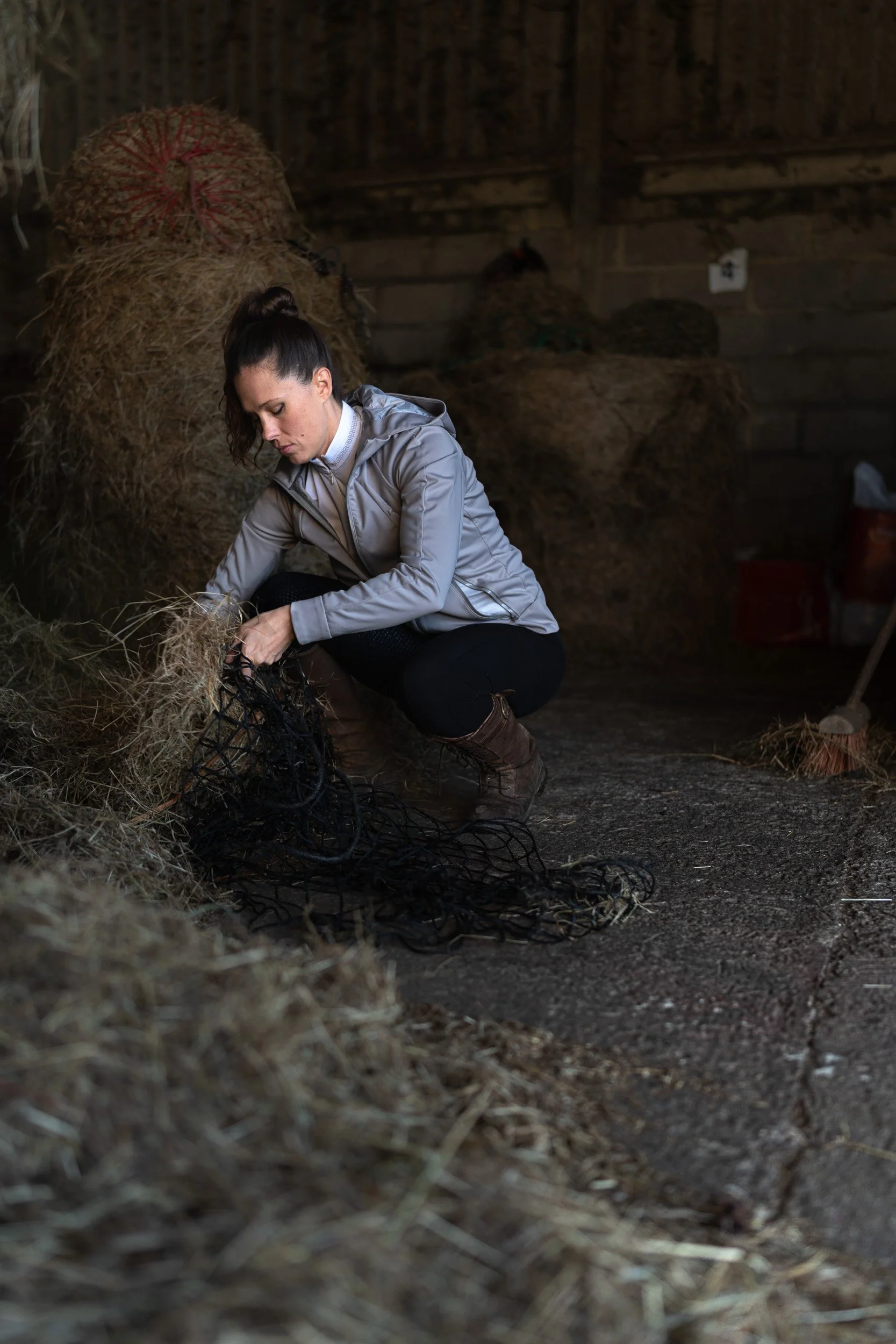 Equestrian fitness coach filling hay bales  at Sean Hardy Horse Training in Great Missenden Buckinghamshire during a branding session