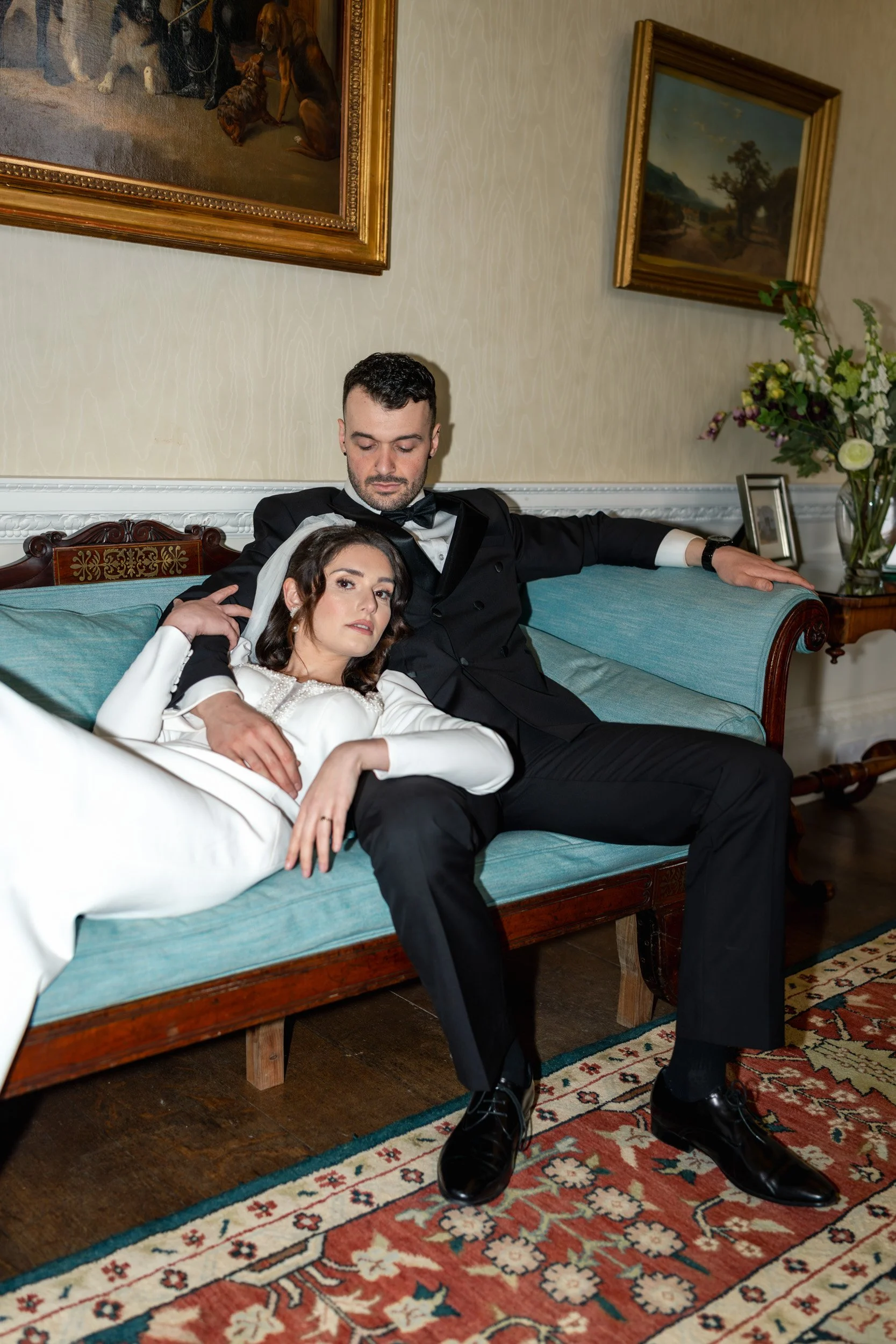 Close up of a bride and groom  lounging together on a sofa  at Kirtlington Park in Oxfordshire