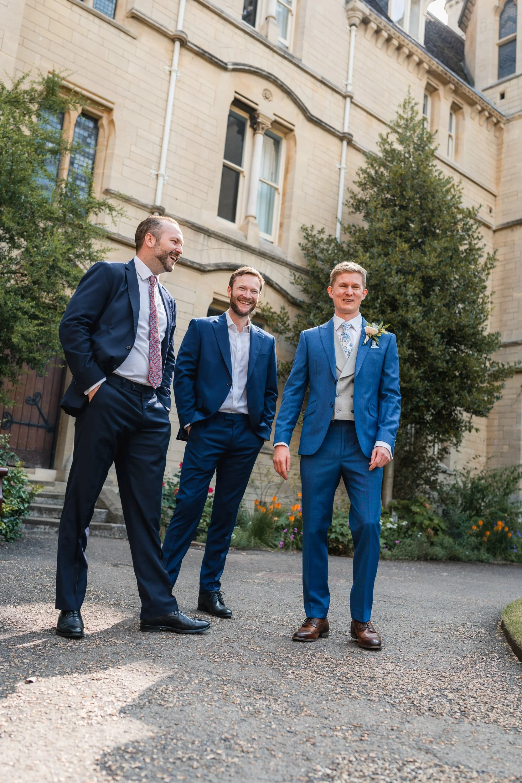 Groomsmen in the courtyard  of an Oxford University college before the wedding ceremony in Oxford, England