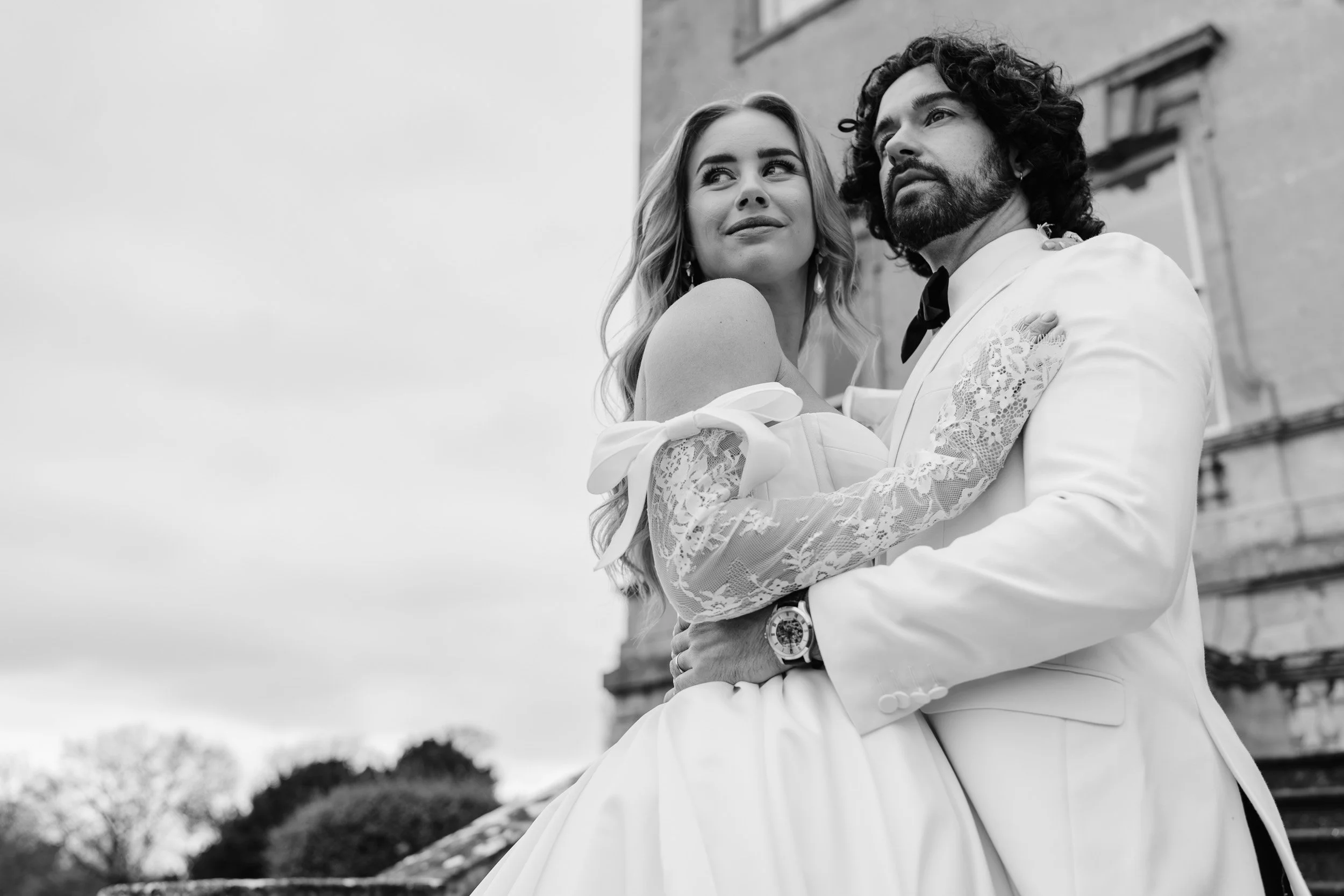 Bride and groom embracing on the front steps of Kirtlington Park in Oxfordshire