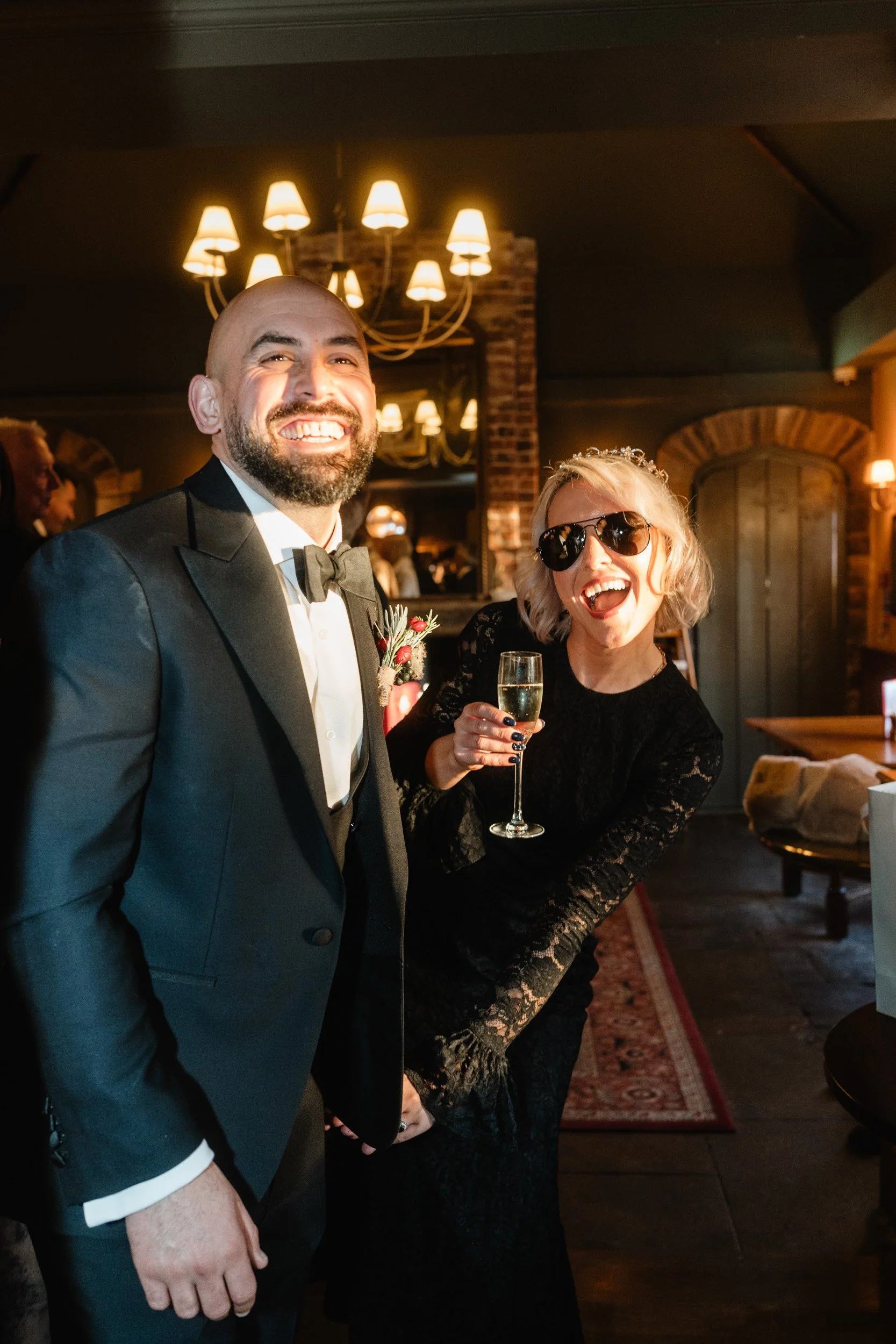 Bride and groom cheering their wedding guests at an evening reception at The Bedford Arms in Chenies, Buckinghamshire