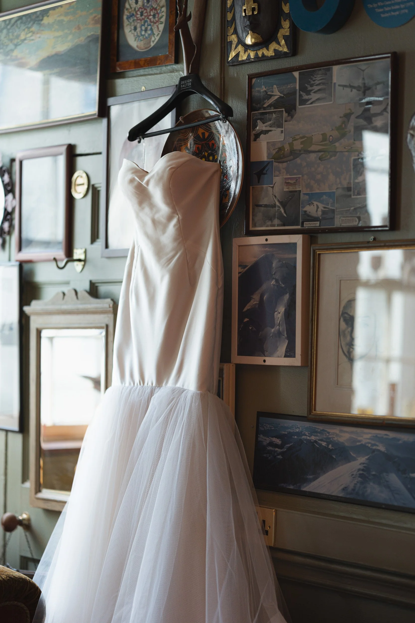 Close up of a wedding dress hanging on a gallery wall in a private room  at The Union Club in Soho, London