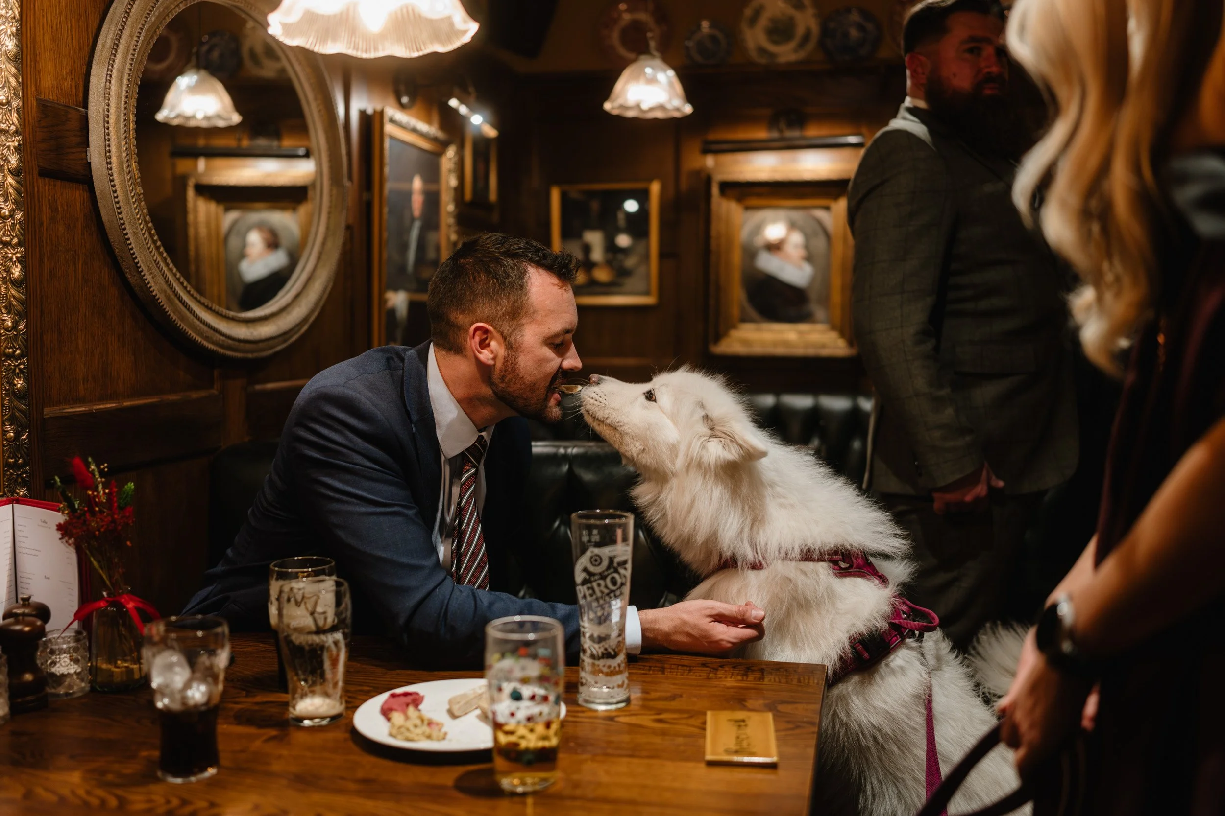 Wedding guest kissing his dog at an intimate  wedding reception at The Bedford Arms in Chenies 