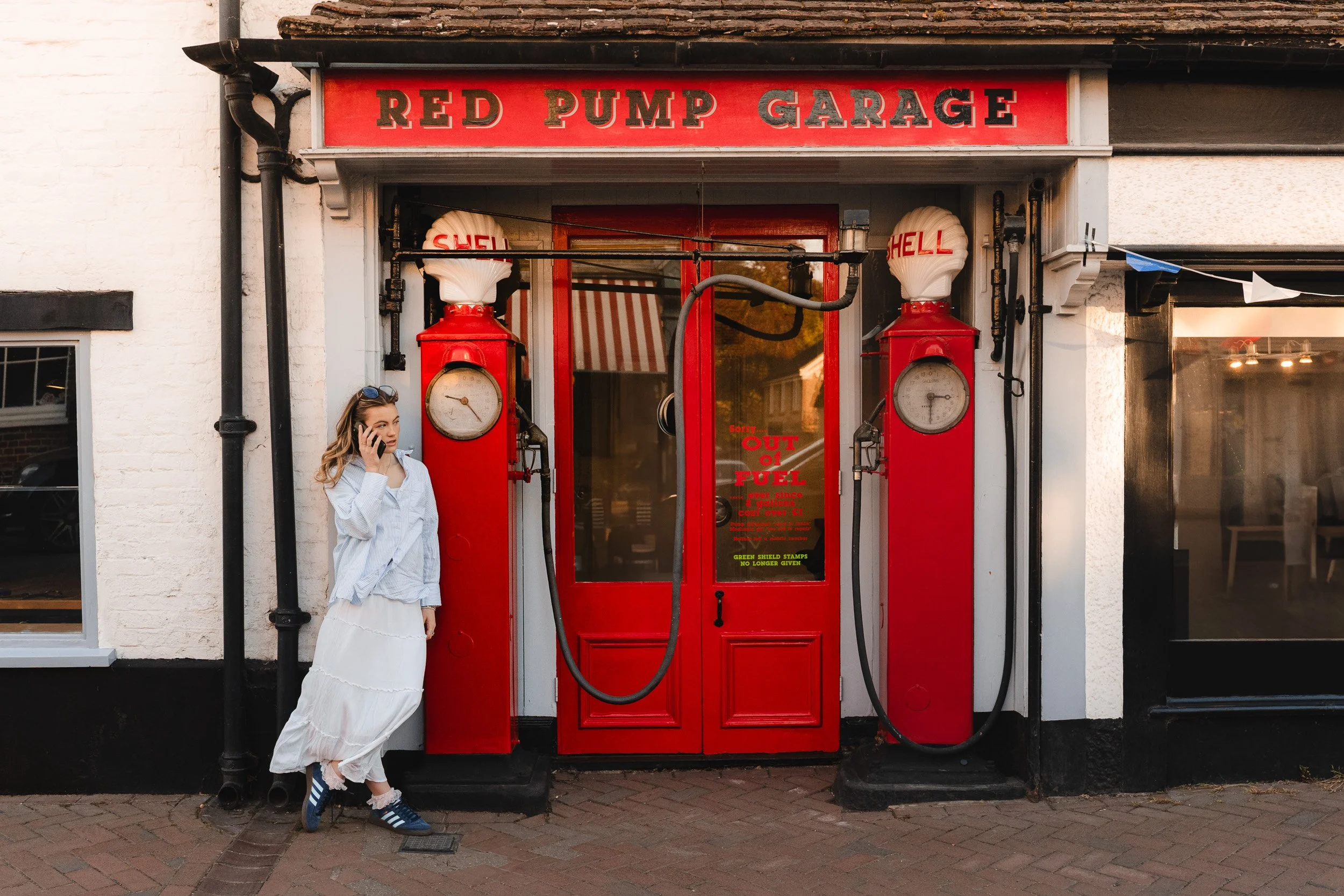 Young woman at her natural school leaver portrait photoshoot at a vintage petrol station during golden hour in Great Missenden, Buckinghamshire