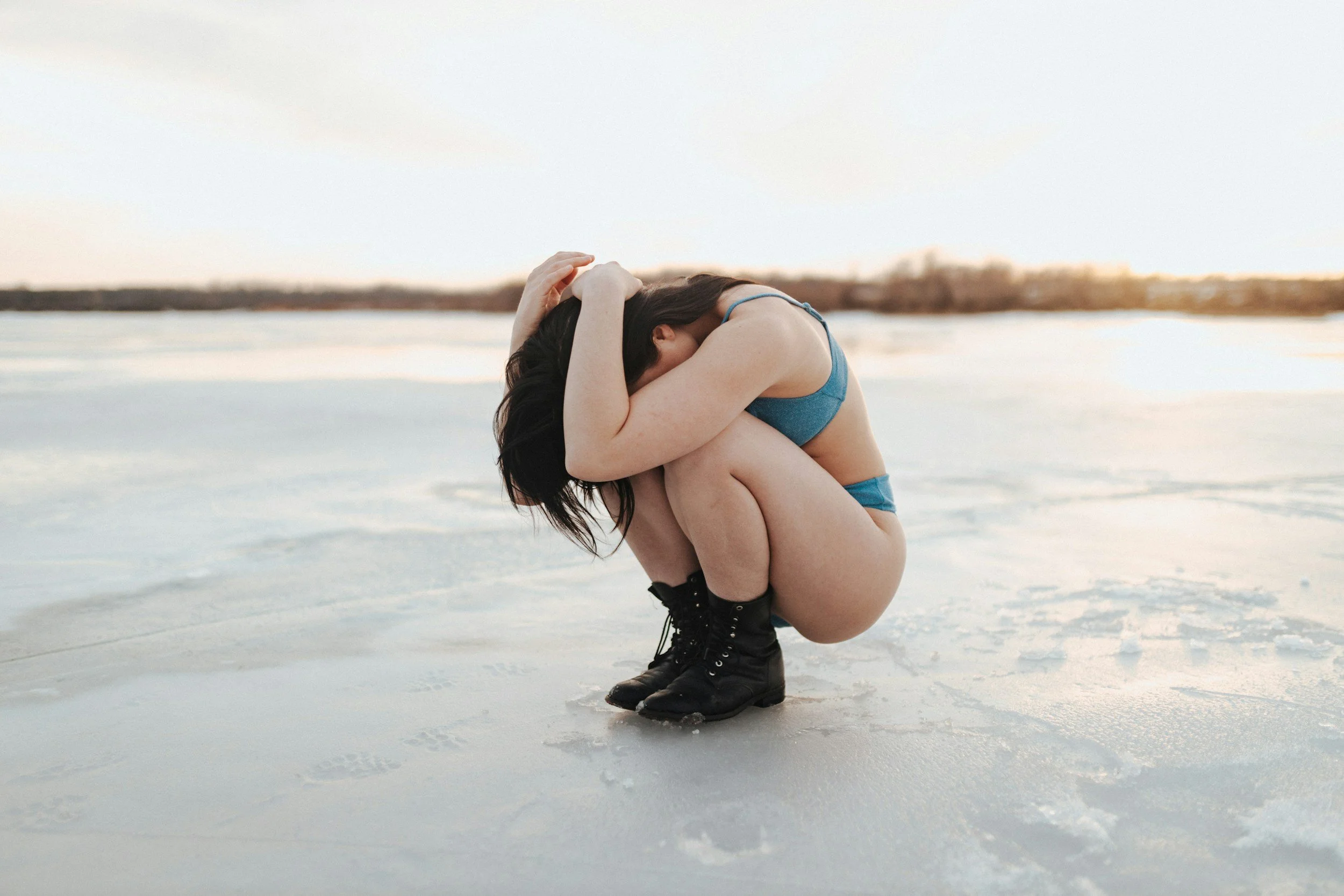 Frau sitzt nachdenklich und zurückgezogen am Wasser – Symbol für fehlende Intimität, Lustlosigkeit und emotionale Distanz. Sexualtherapie und Sexualberatung in Nürnberg und online bei Problemen mit Nähe, Leidenschaft und sexueller Verbindung.