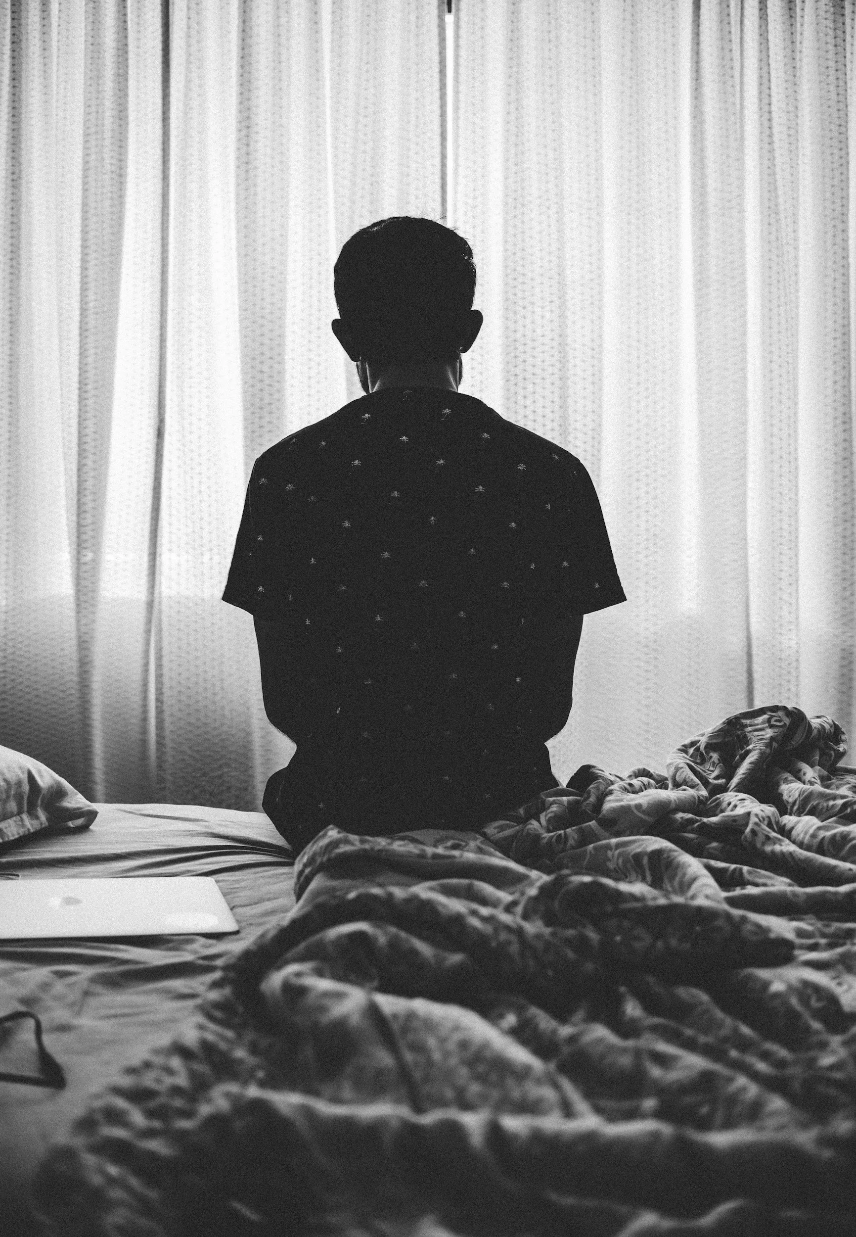 Nachdenkliche Person sitzt allein auf einem Bett als Symbol für Einsamkeit, Selbstzweifel und wiederkehrende Beziehungsmuster. Single- und Beziehungscoaching online und in Nürnberg.