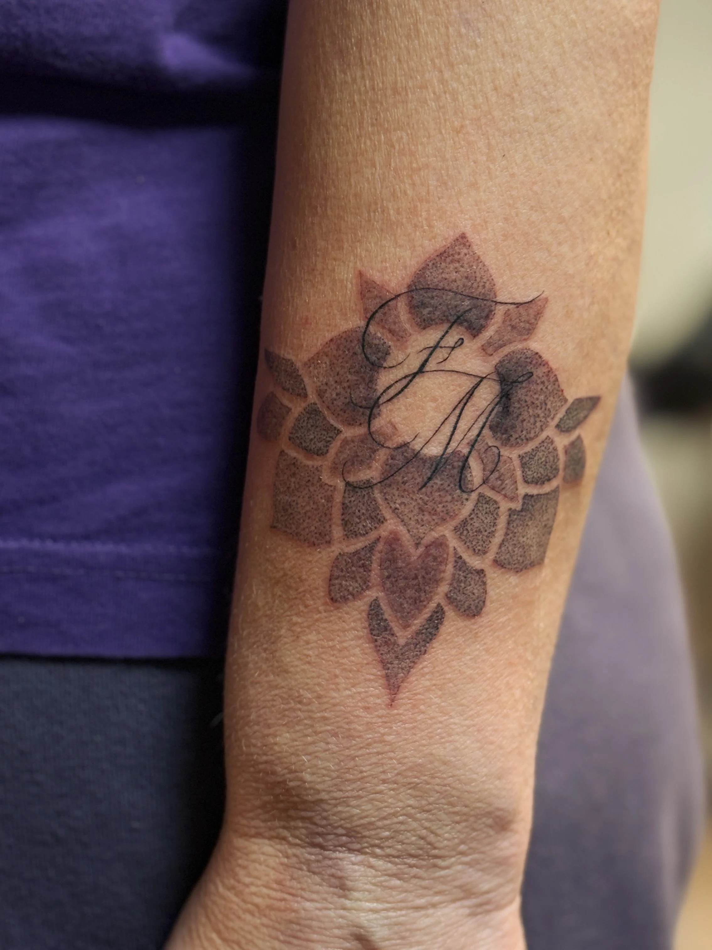 Tattoo af en giraffeskildpadde med initialer J M skriftligt i midten.