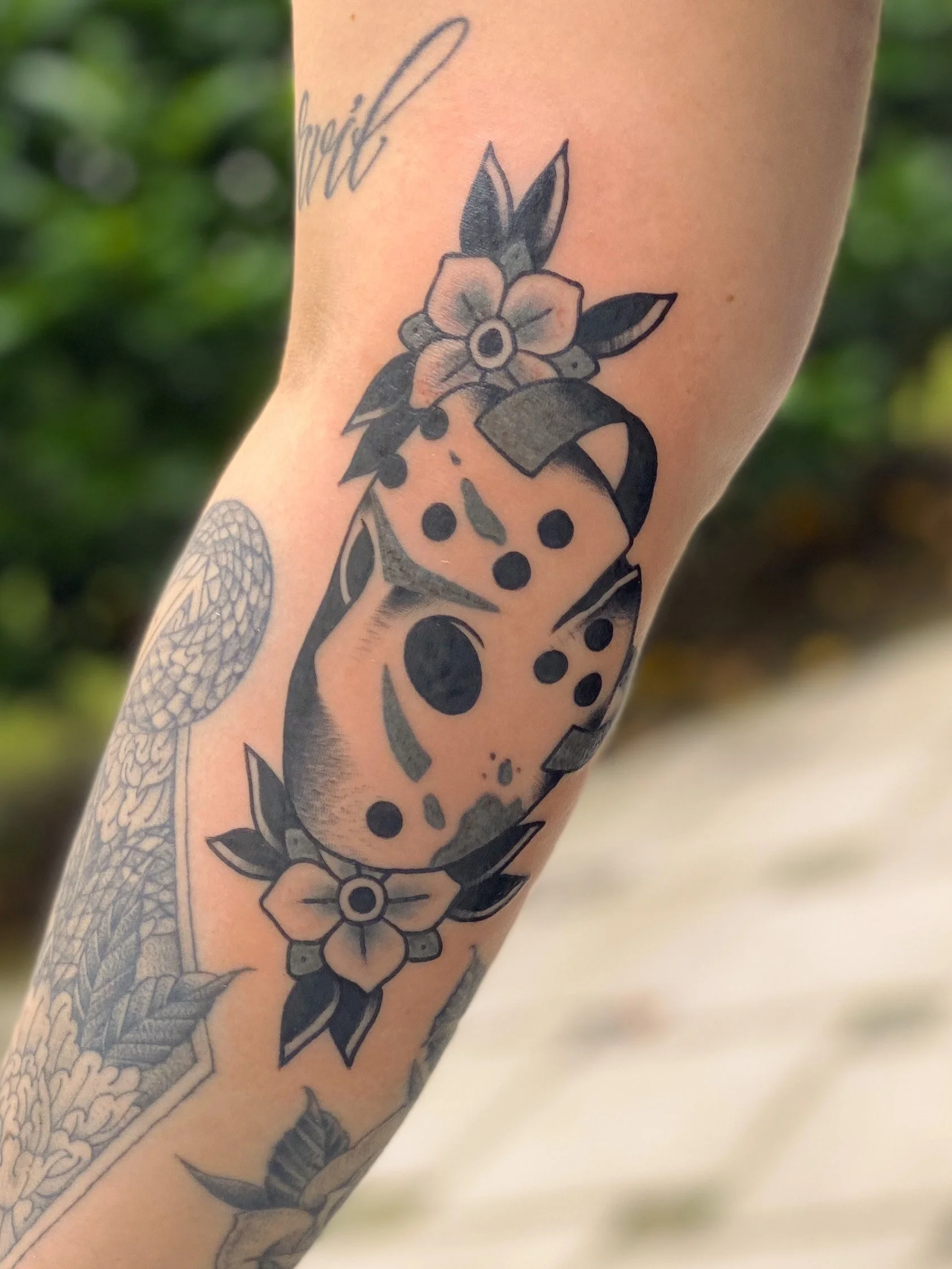 Tatovering af en hunderace med blomster, sort-hvid stil.