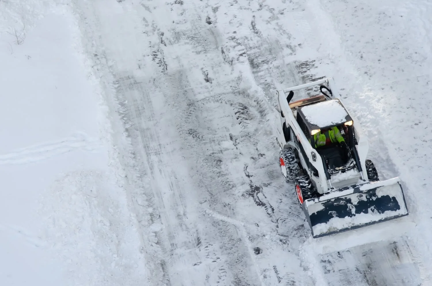 A snowplow clearing snow from a snow-covered road.