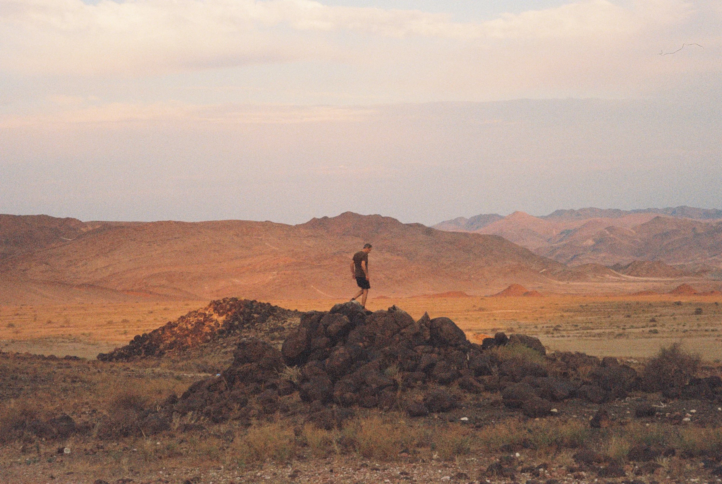 Man on rocks: Brand strategist Alex Hayn standing in a wild Namibian landscape, symbolizing the forensic and grounded approach of Fine Tooth brand integrity audits.
