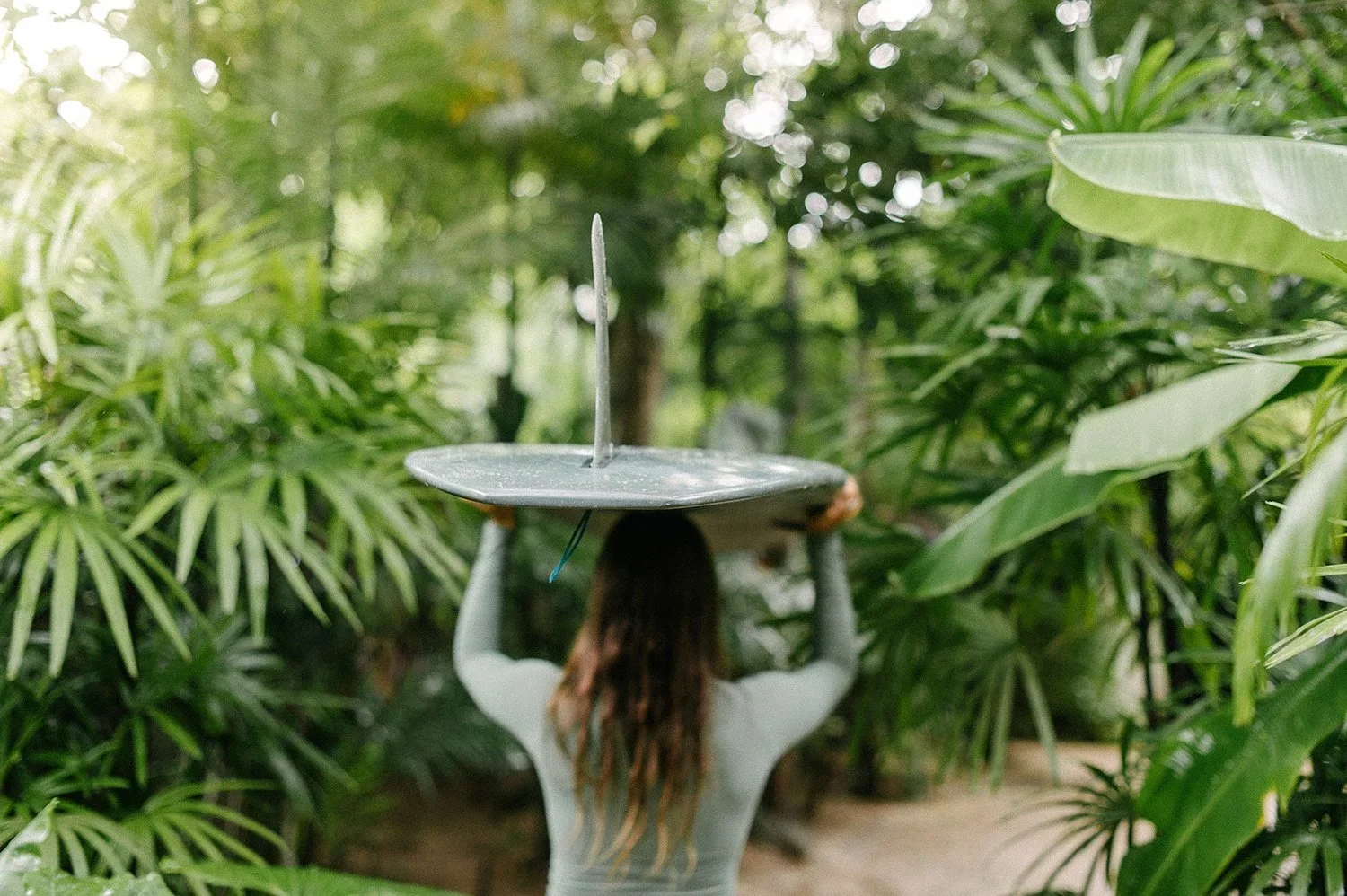 Person with surfboard: A tropical hospitality guest experience highlighting the importance of authentic, unscripted moments in luxury lifestyle branding.