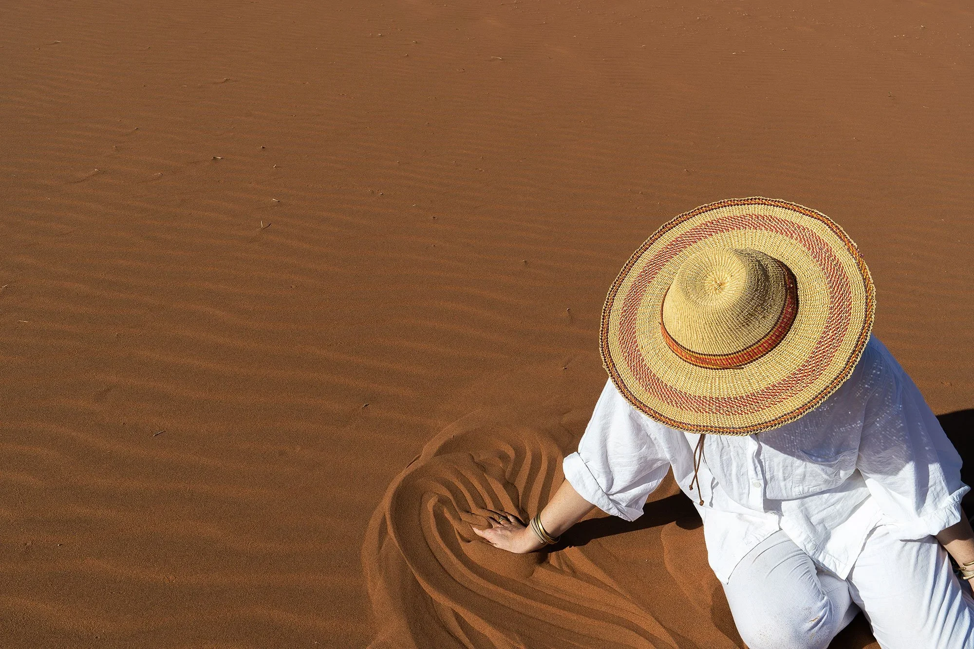Person drawing in sand: The "Fine Tooth" approach to mapping out a brand’s ecosystem, ensuring every guest interaction is intentional and strategically aligned.