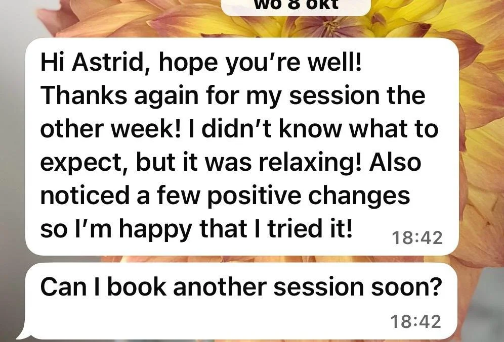 Screenshot van een WhatsApp-gesprek met een achtergrond van een bloem. Het bericht bedankt Astrid voor een sessie, meldt positieve veranderingen en vraagt of er een nieuwe afspraak gemaakt kan worden.