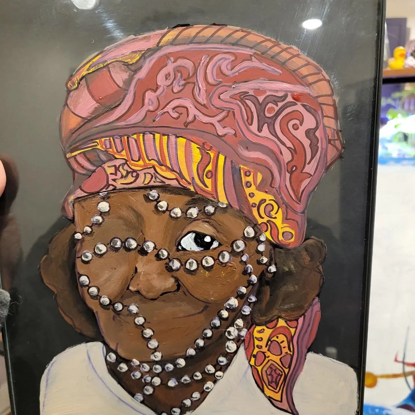 A colorful portrait of a woman with dark skin, wearing a patterned headscarf and multiple strands of pearls, with a bright and expressive face.