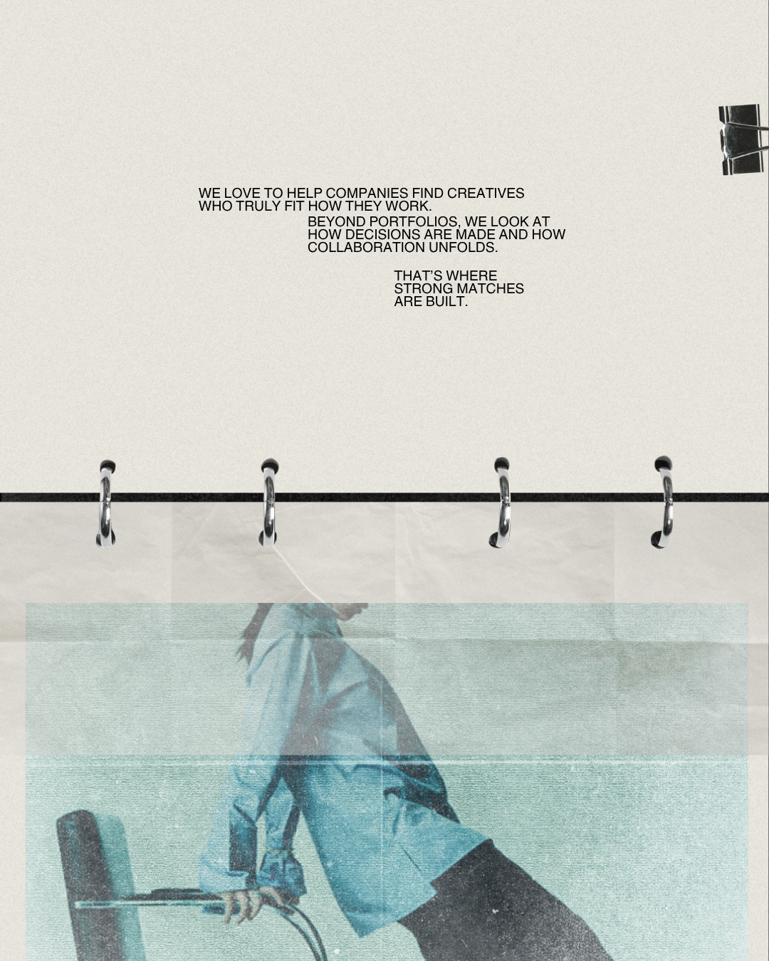 A close-up of a printed paper with a motivational quote about helping companies find creatives and how strong matches are built, clipped at the top right corner, with a blurred outdoor scene at the bottom showing a person walking with an umbrella.