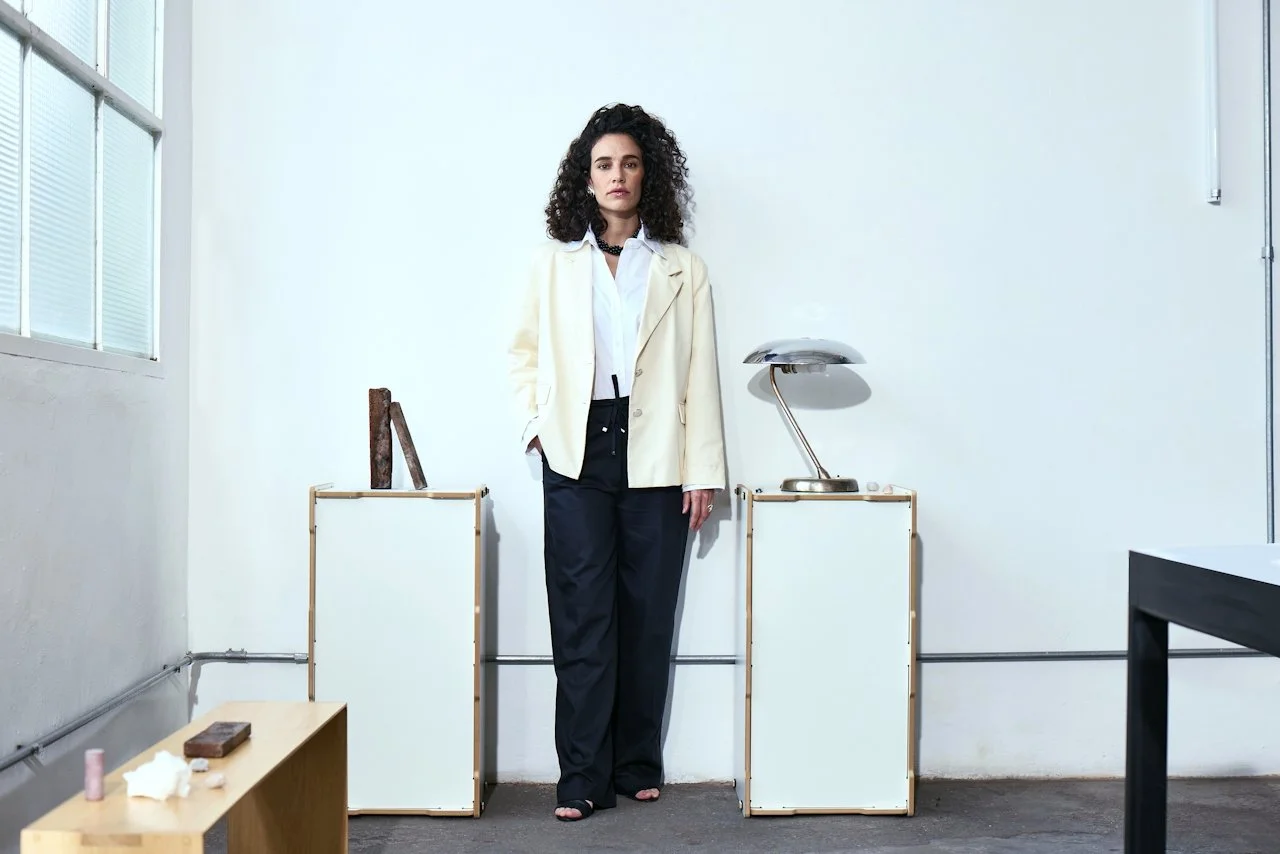 Collection of photos including a woman with dark hair and large earring, a woman sitting with a laptop, stationery supplies, and textile label reading "NNH" with logo.