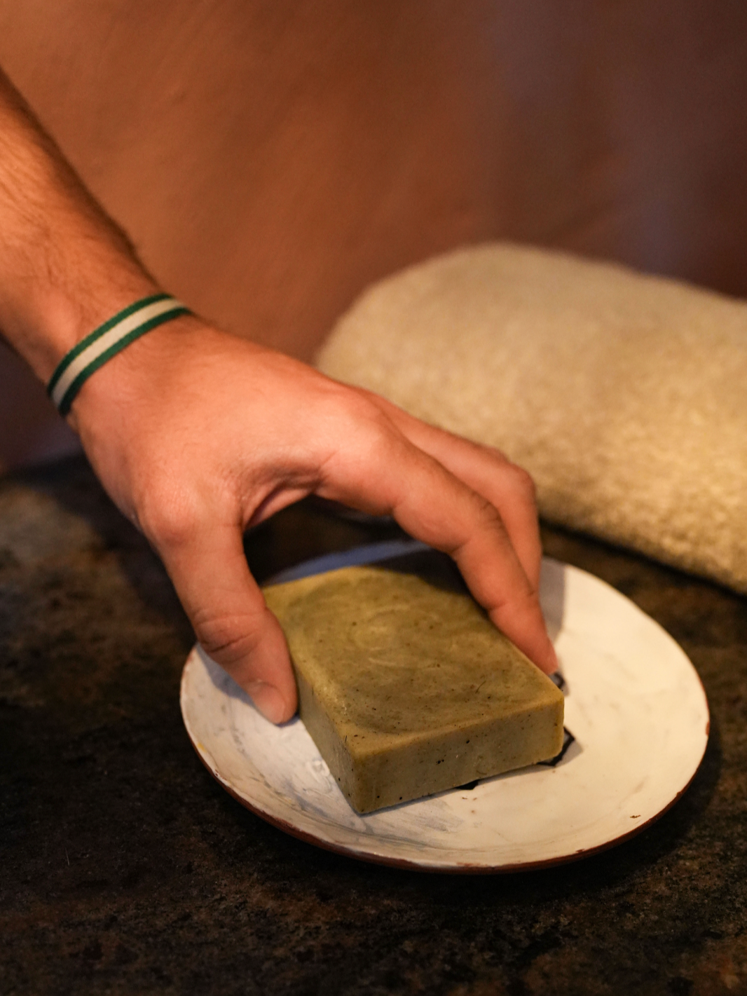 Persona tocando una barra de jabón para el cabello de Ajedrea Cosmetica Ecologica.