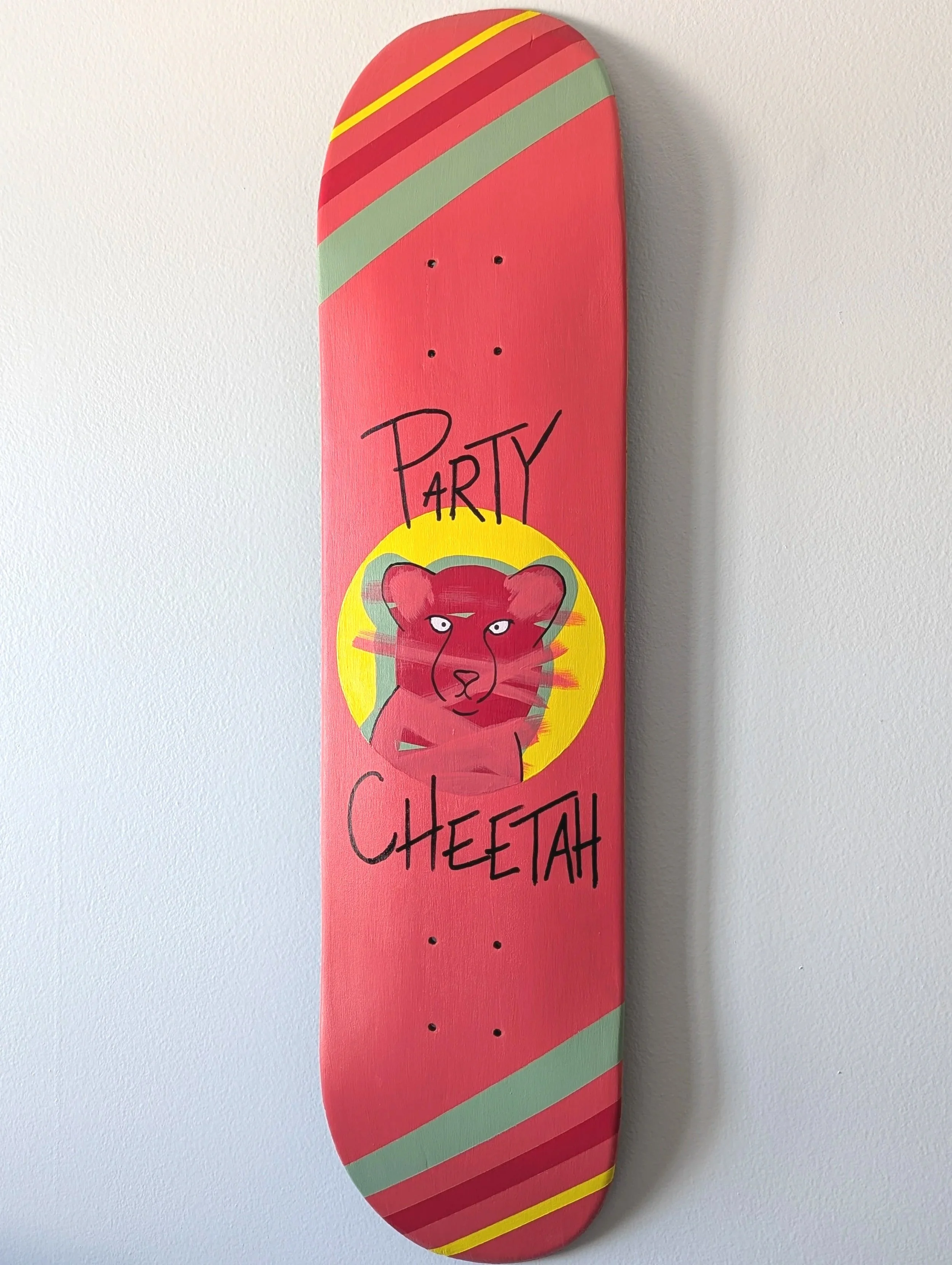 Pink skateboard deck with a graphic of a cheetah's face inside a yellow circle, with the words "PARTY CHEETAH" written above and below the graphic.