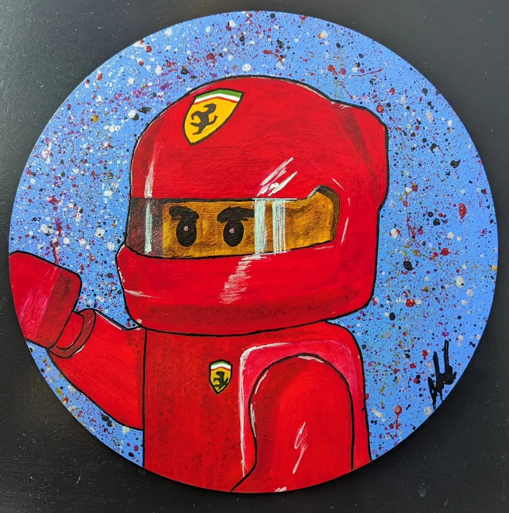 Painting of a red Lego-style racing driver with a yellow and black badge, set against a blue and speckled background.