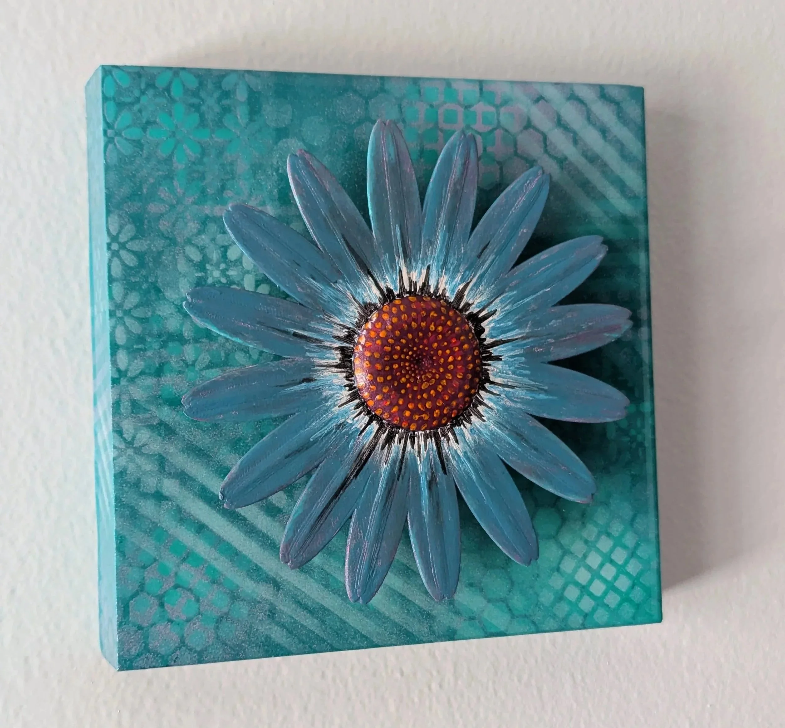 Blue painting with an elevated flower popping out of the painting