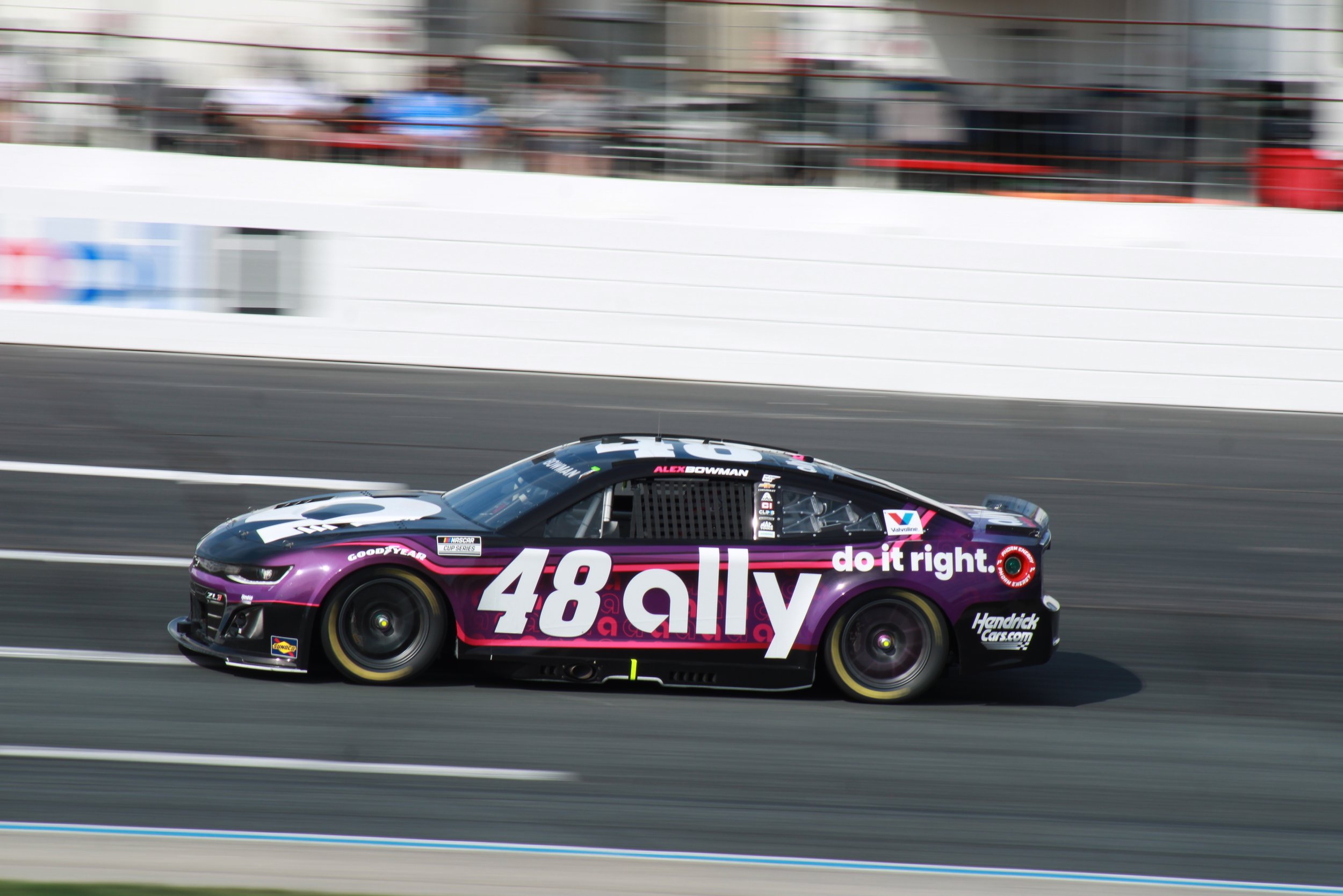 A race car on a track with a black body and purple decals, featuring the number 48 and the words 'ally' and 'do it right'.