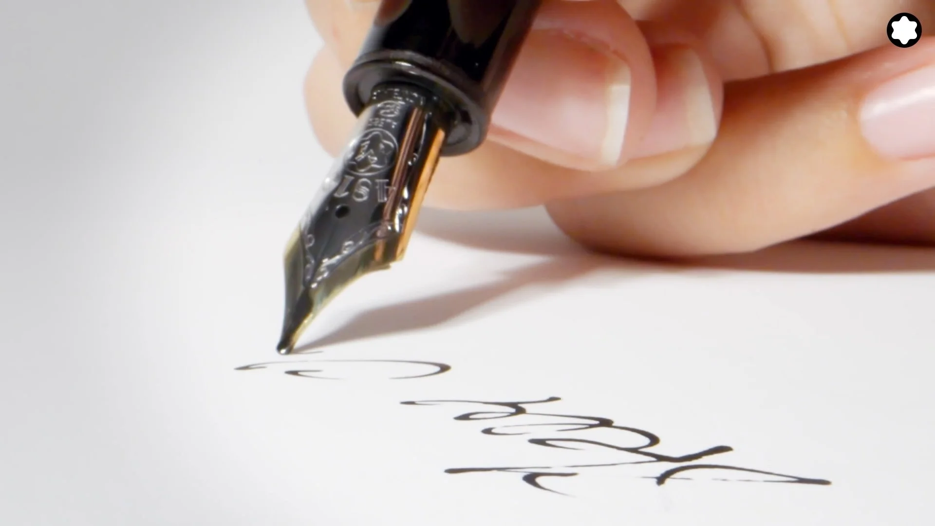 Plan d'accroche avec l'emblème de la marque, le stylo plume.