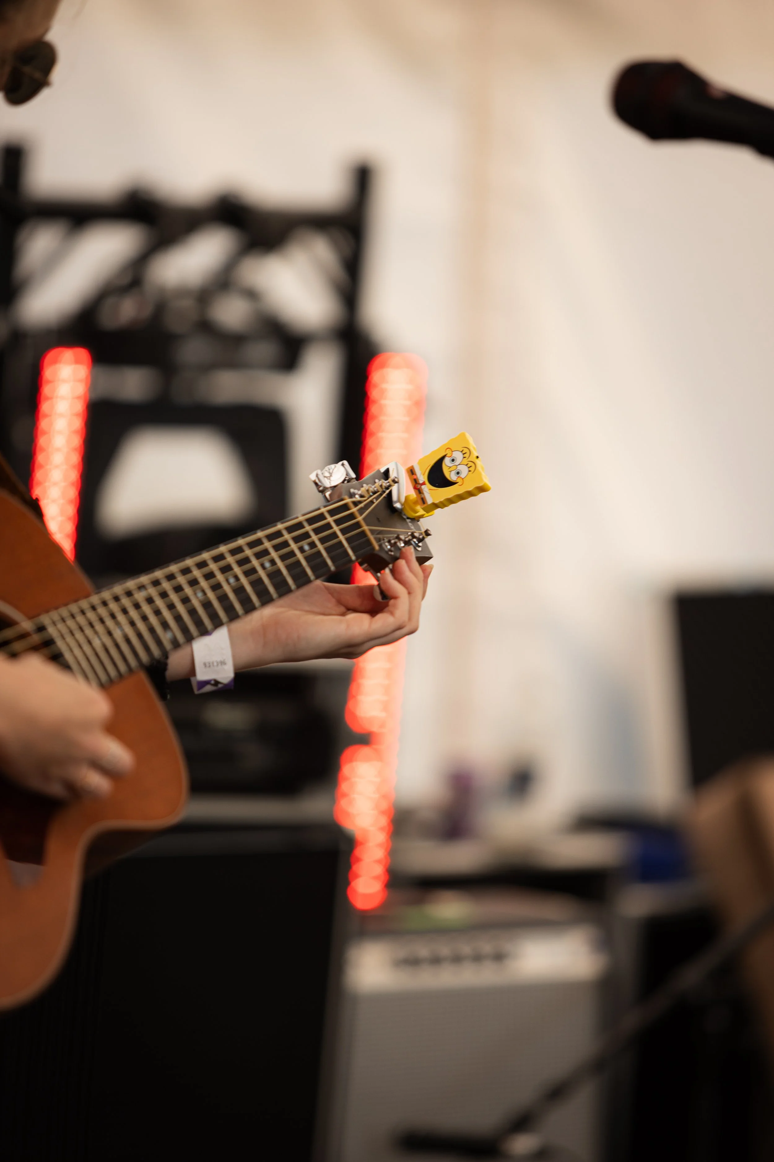 Close-up of Louise Parker playing acoustic guitar during a live country pop music performance, showcasing original songs at a UK festival and live music event in Essex.