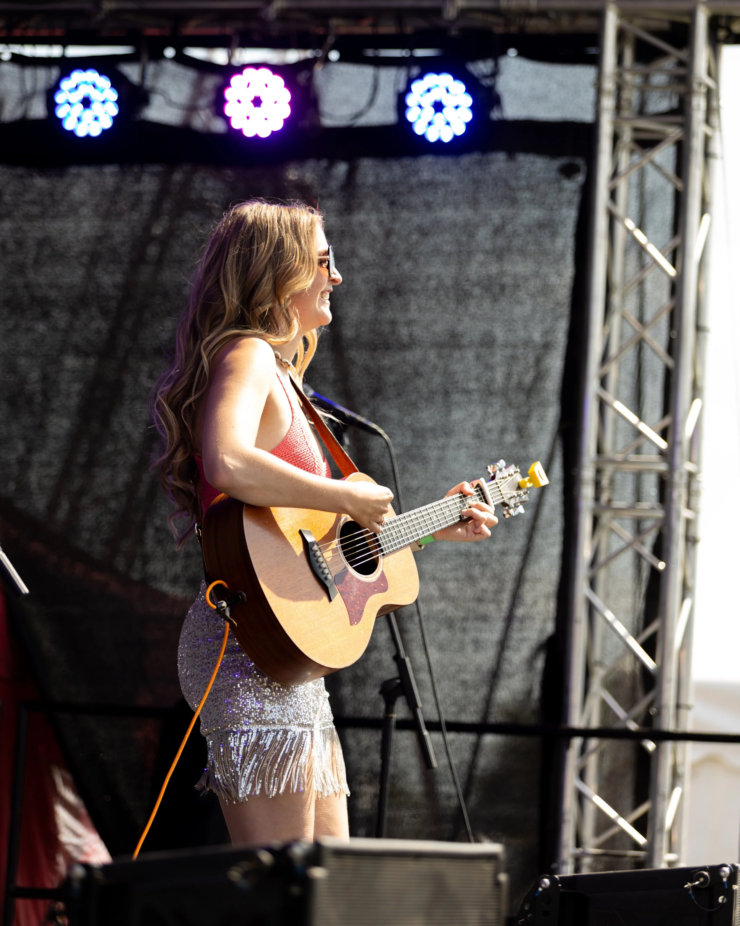 Essex country pop singer-songwriter Louise Parker performing a live outdoor festival set with acoustic guitar.