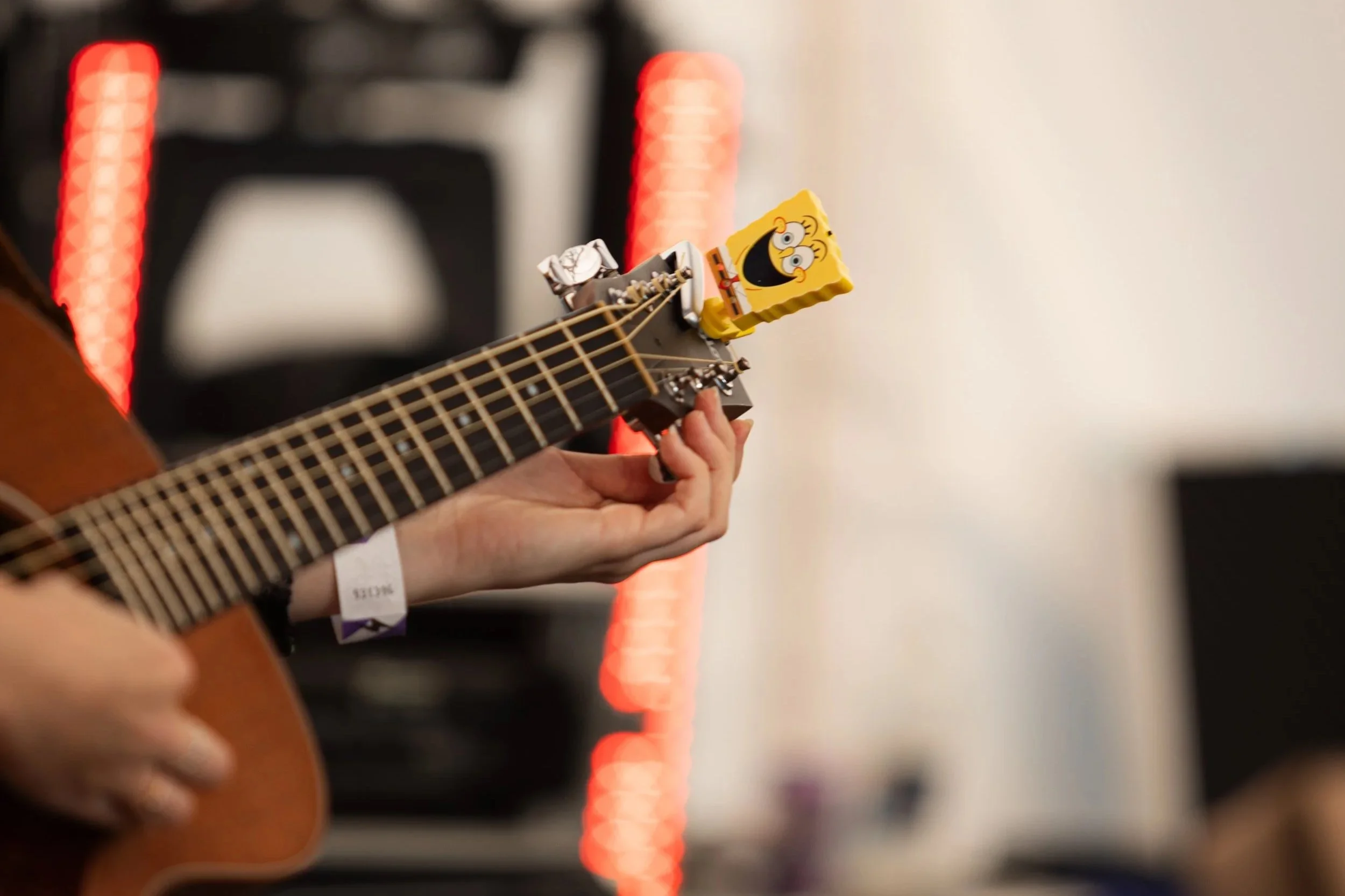 Close-up of Louise Parker playing acoustic guitar during a live UK country pop performance.