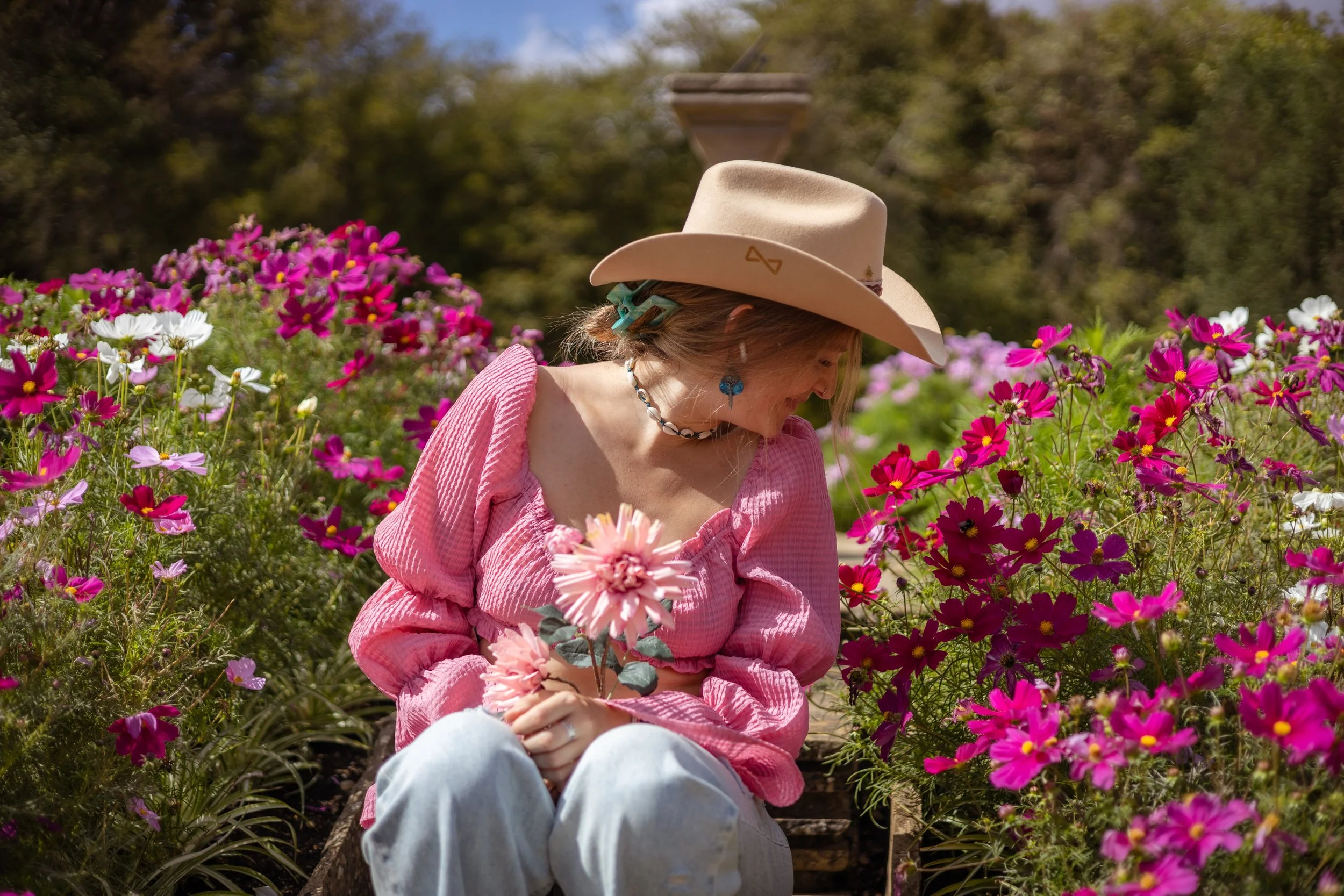 Louise Parker, Essex country-pop singer-songwriter, surrounded by flowers in a cowboy hat